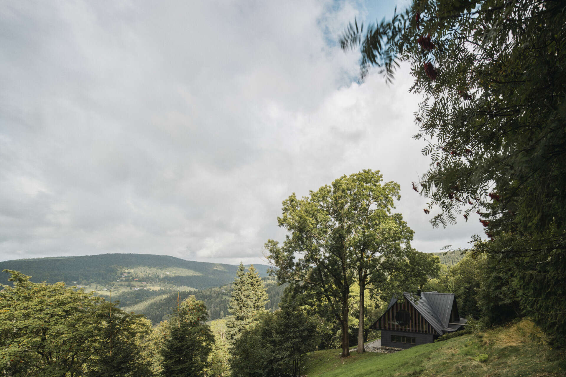 Traditional mountain cottage with steep roofs, stone bases, and timber gables blending authentic design with modern simplicity.