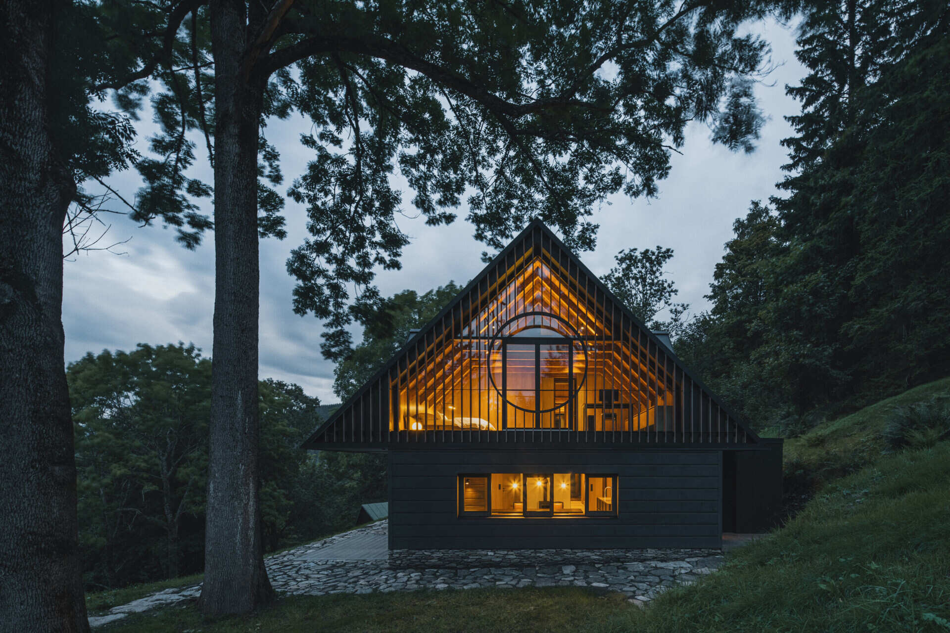 Traditional mountain cottage with steep roofs, stone bases, and timber gables blending authentic design with modern simplicity.