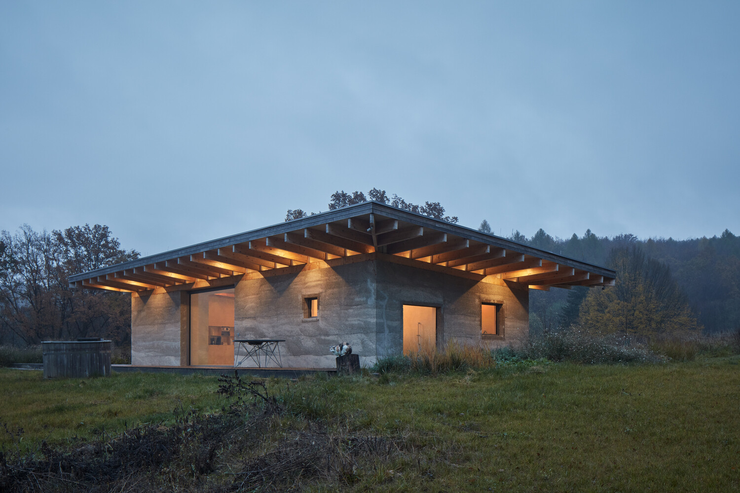 A modern forest cabin built with hempcrete walls, a timber frame, and a green roof, combines natural materials with sustainable design.