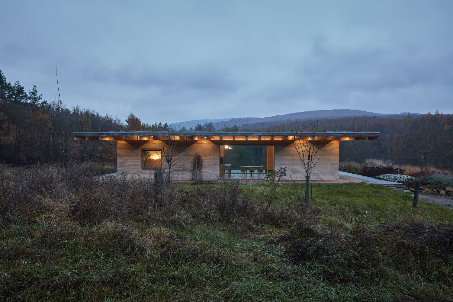 A modern forest cabin built with hempcrete walls, a timber frame, and a green roof, combines natural materials with sustainable design.