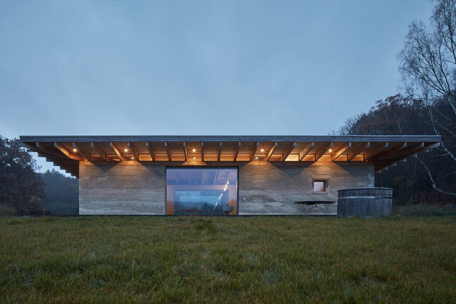 A modern forest cabin built with hempcrete walls, a timber frame, and a green roof, combines natural materials with sustainable design.