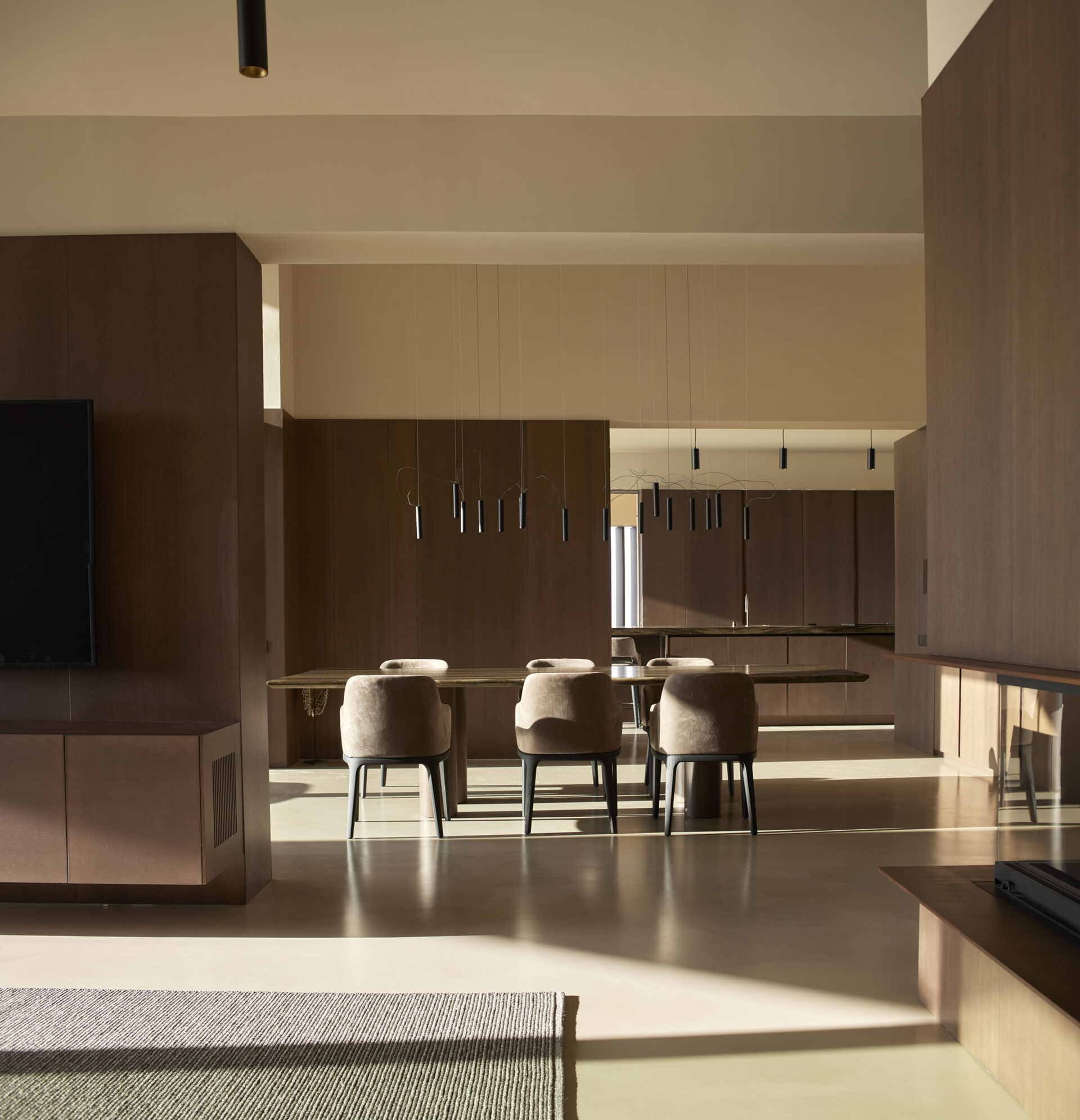 An open-plan dining space connects effortlessly with the kitchen and living areas, framed by views and natural materials.