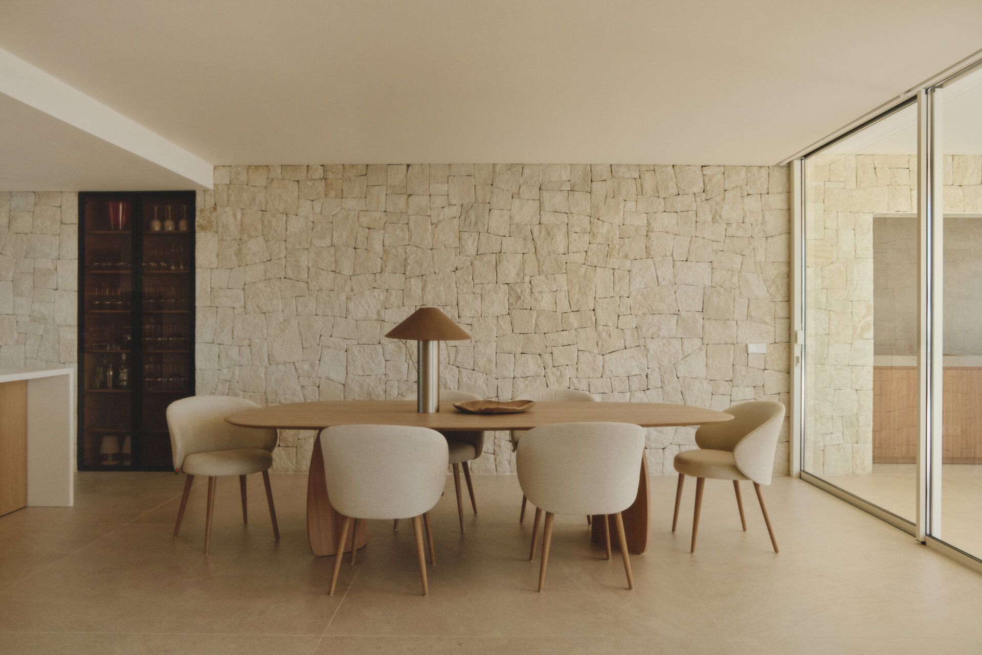 The dining area sits beside expansive glazing, keeping the Mediterranean horizon constantly present.