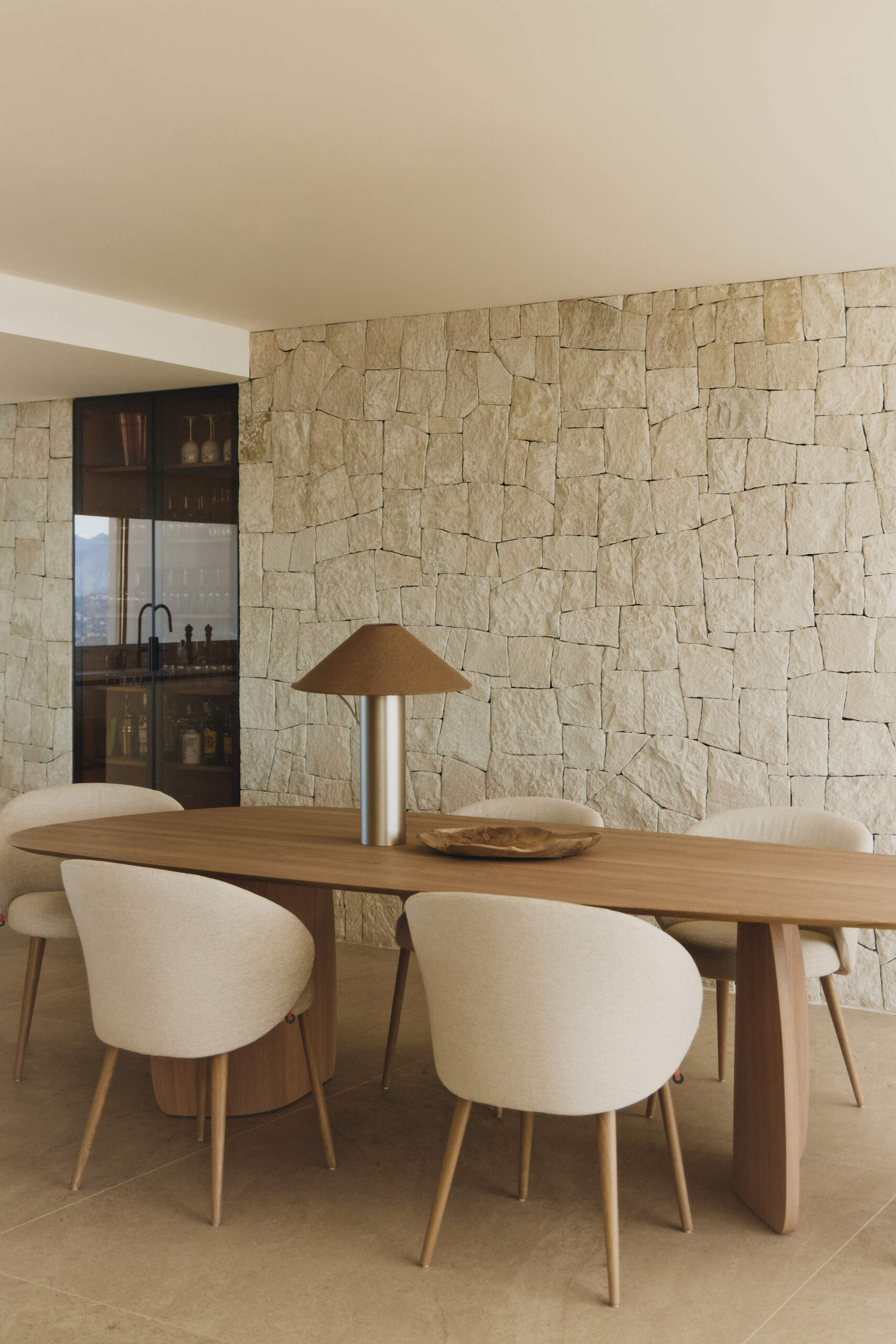 The dining area sits beside expansive glazing, keeping the Mediterranean horizon constantly present.