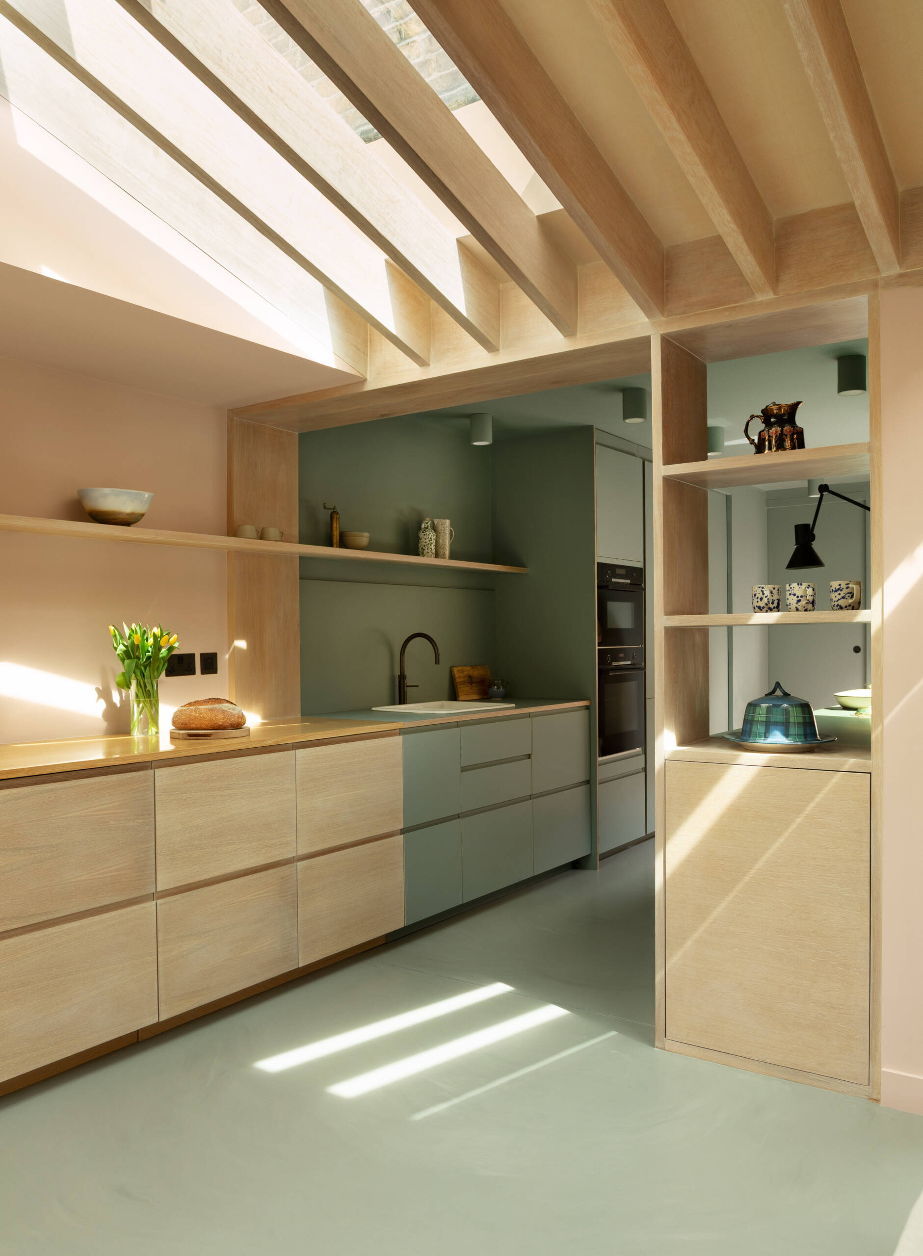 Una extensión inspirada en una cabaña de Turner Architects transforma el borde de un pequeño jardín urbano en un espacio de salón y cocina sólido y basado en materiales.