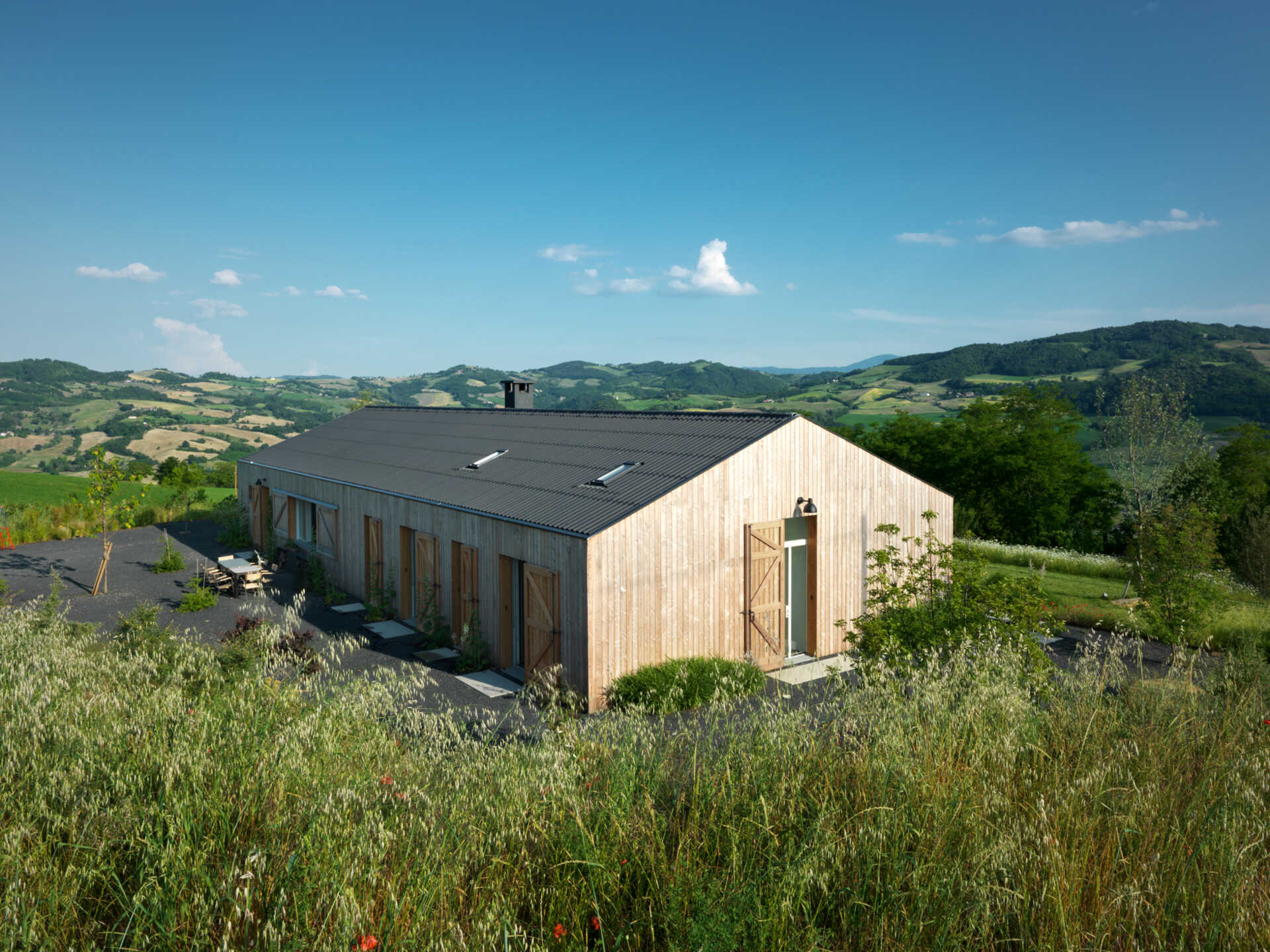 The farmhouse’s larch wood siding ages to a soft gray, offering natural insulation and blending seamlessly into the Italian countryside.