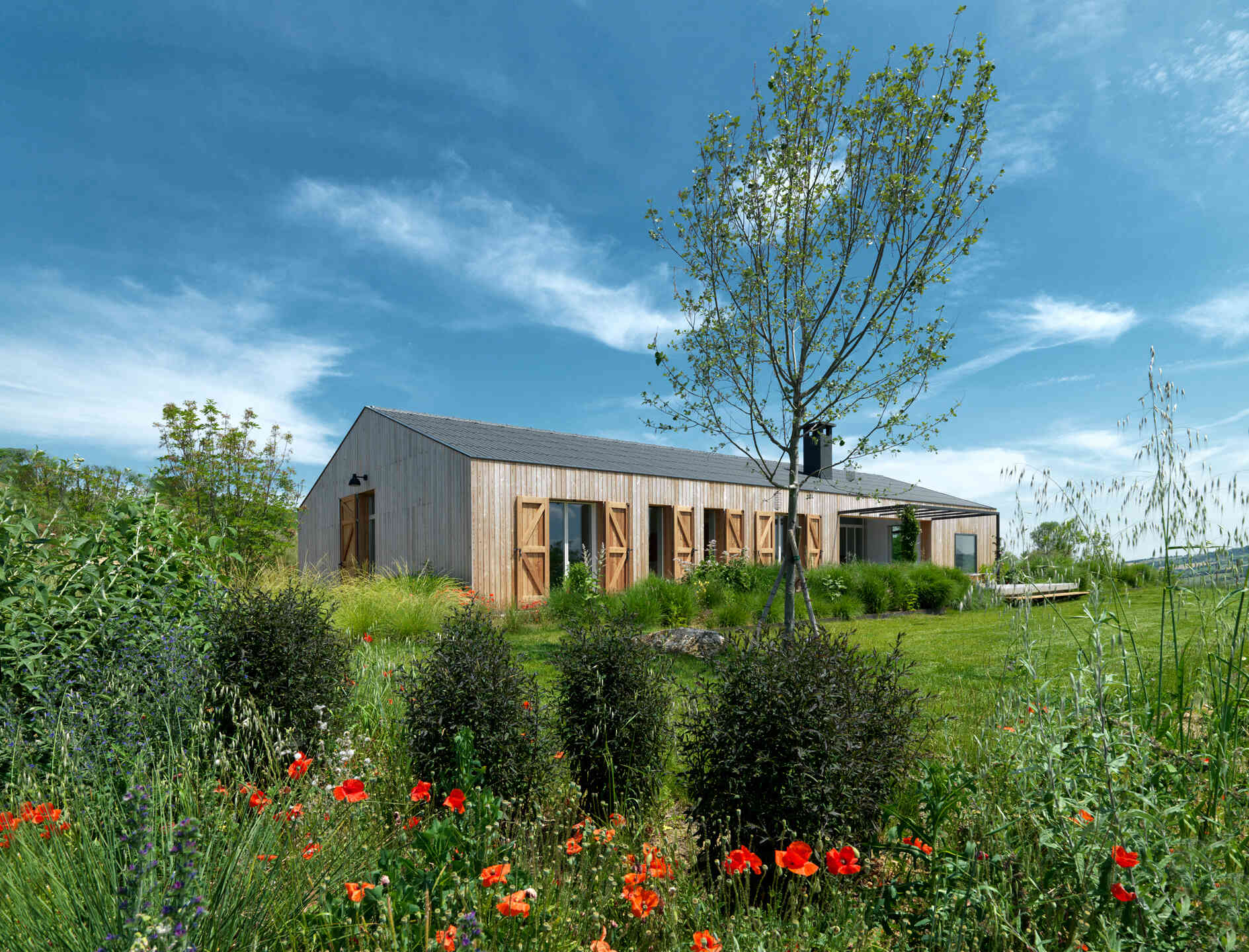 The farmhouse’s larch wood siding ages to a soft gray, offering natural insulation and blending seamlessly into the Italian countryside.