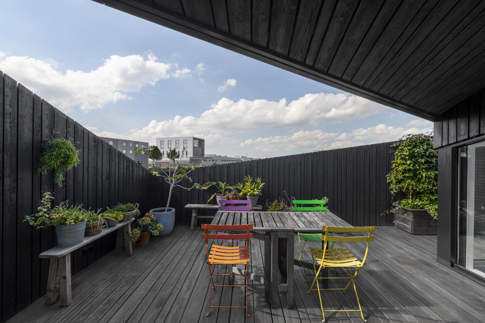 Angled walls create privacy on the rooftop deck while keeping the space open to the sky and water.