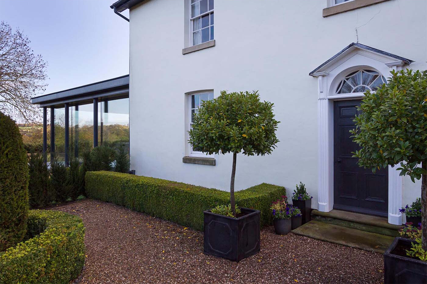 A modern glass extension adds a fresh layer to this historic English cottage, blending old charm with contemporary design.