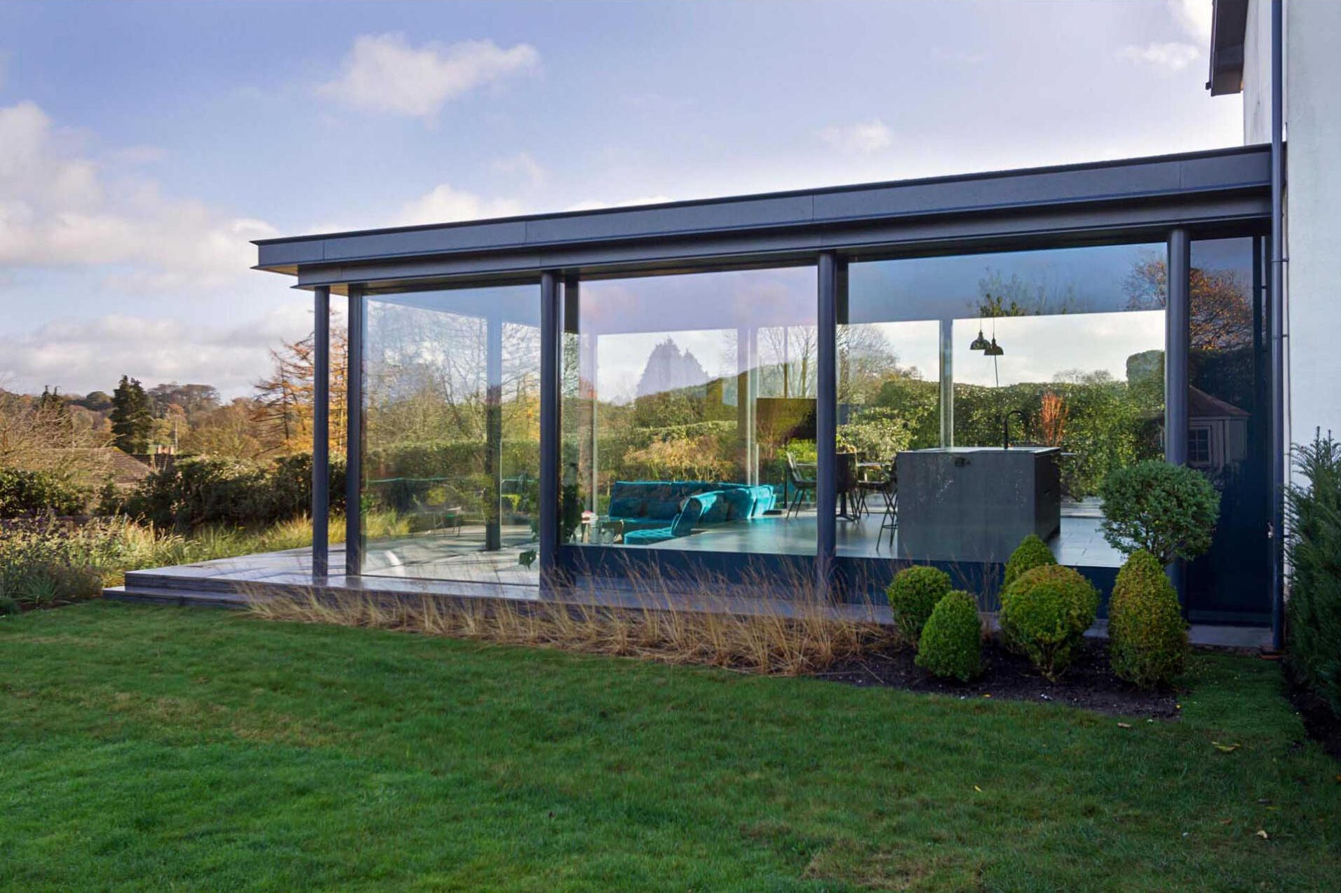 A sleek glass extension replaces outdated outbuildings, bringing light and flexibility to a historic cottage.