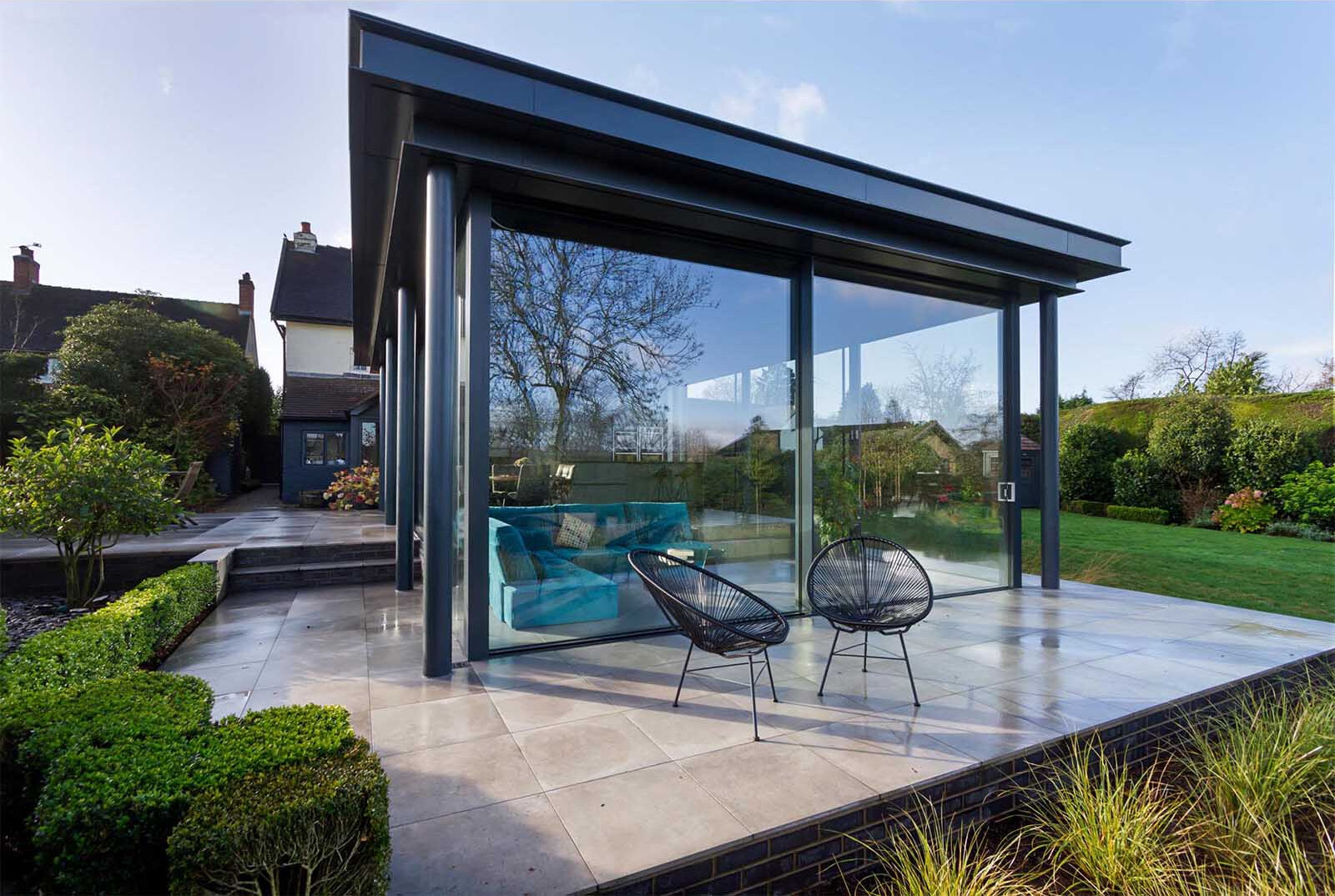 A spacious patio extends the living area outdoors, creating the perfect setup for dining and relaxing in the garden.