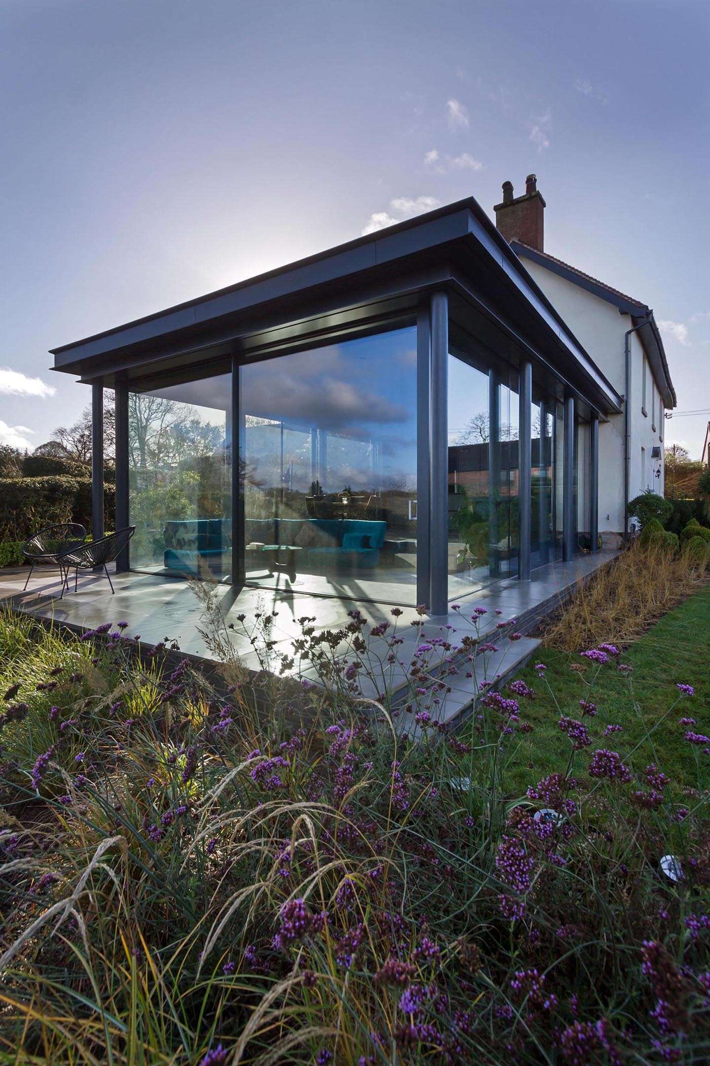 A sleek glass extension replaces outdated outbuildings, bringing light and flexibility to a historic cottage.