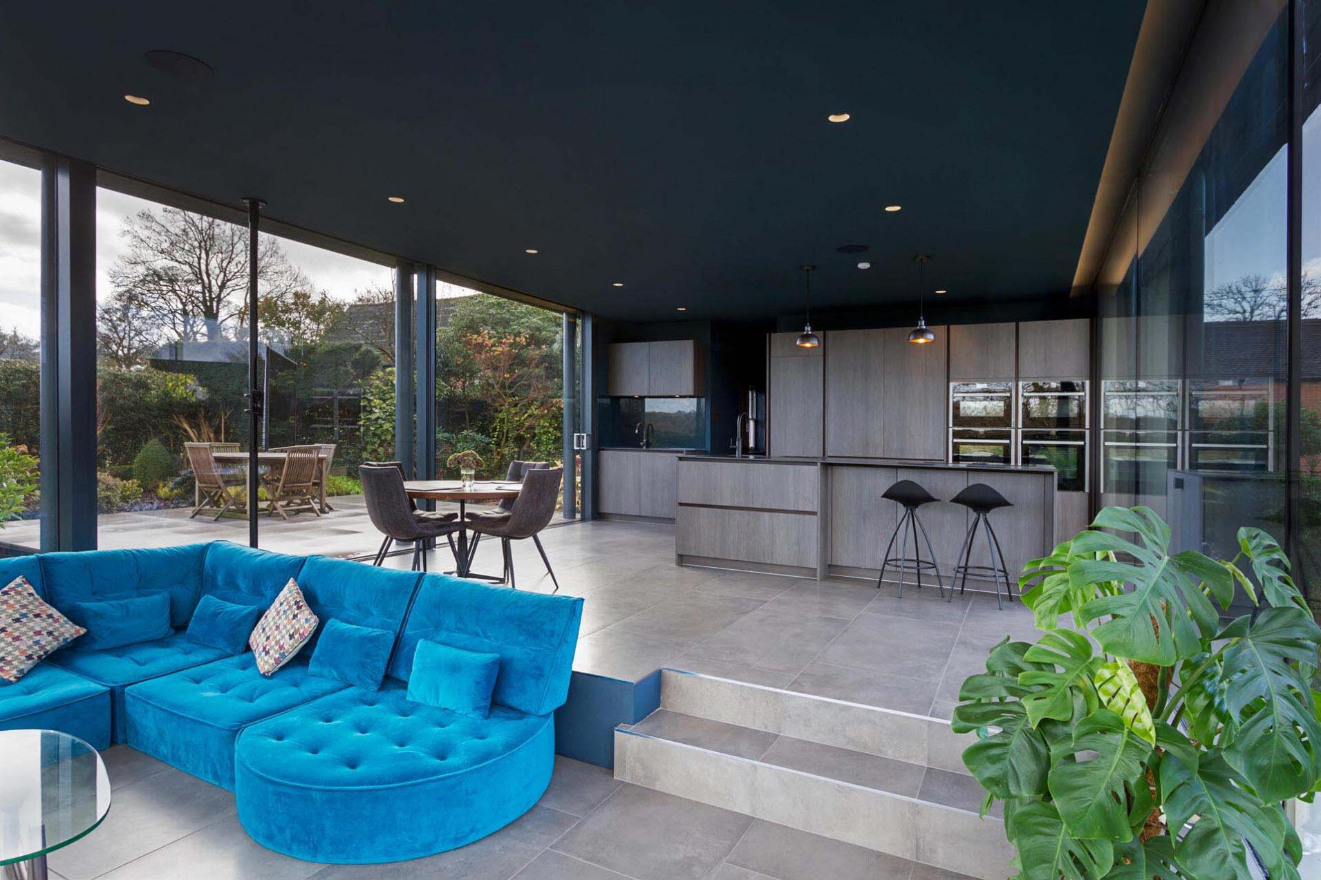 A dark ceiling and clever lighting design make this glass extension perfect for evening use and stargazing.