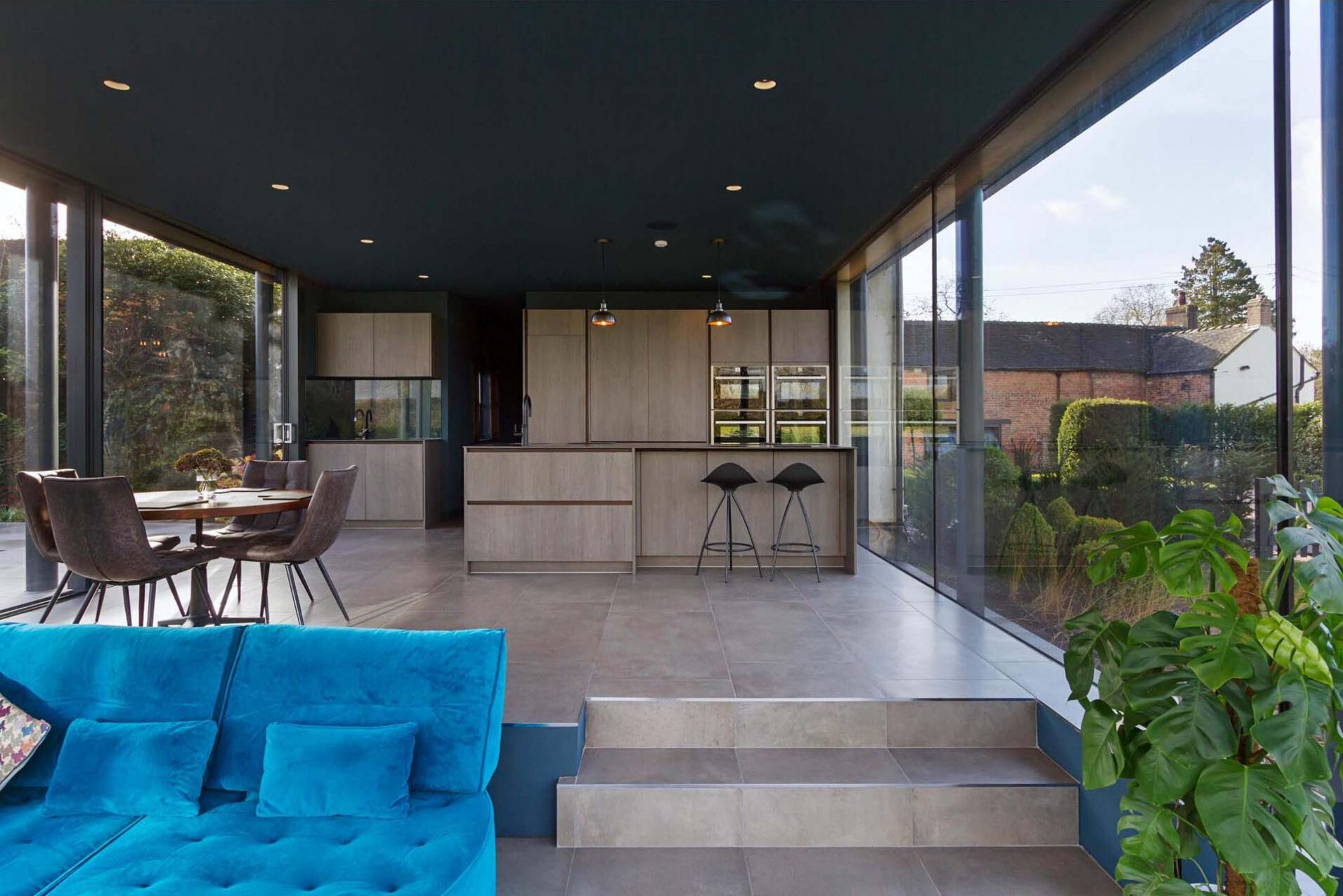 A dark ceiling and clever lighting design make this glass extension perfect for evening use and stargazing.