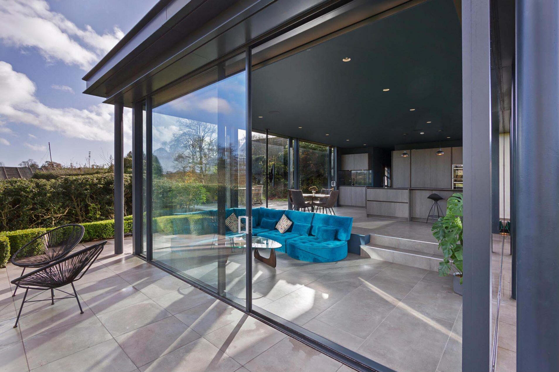 Floor-to-ceiling glass doors bring in natural light and fresh air, creating a bright and open living space.