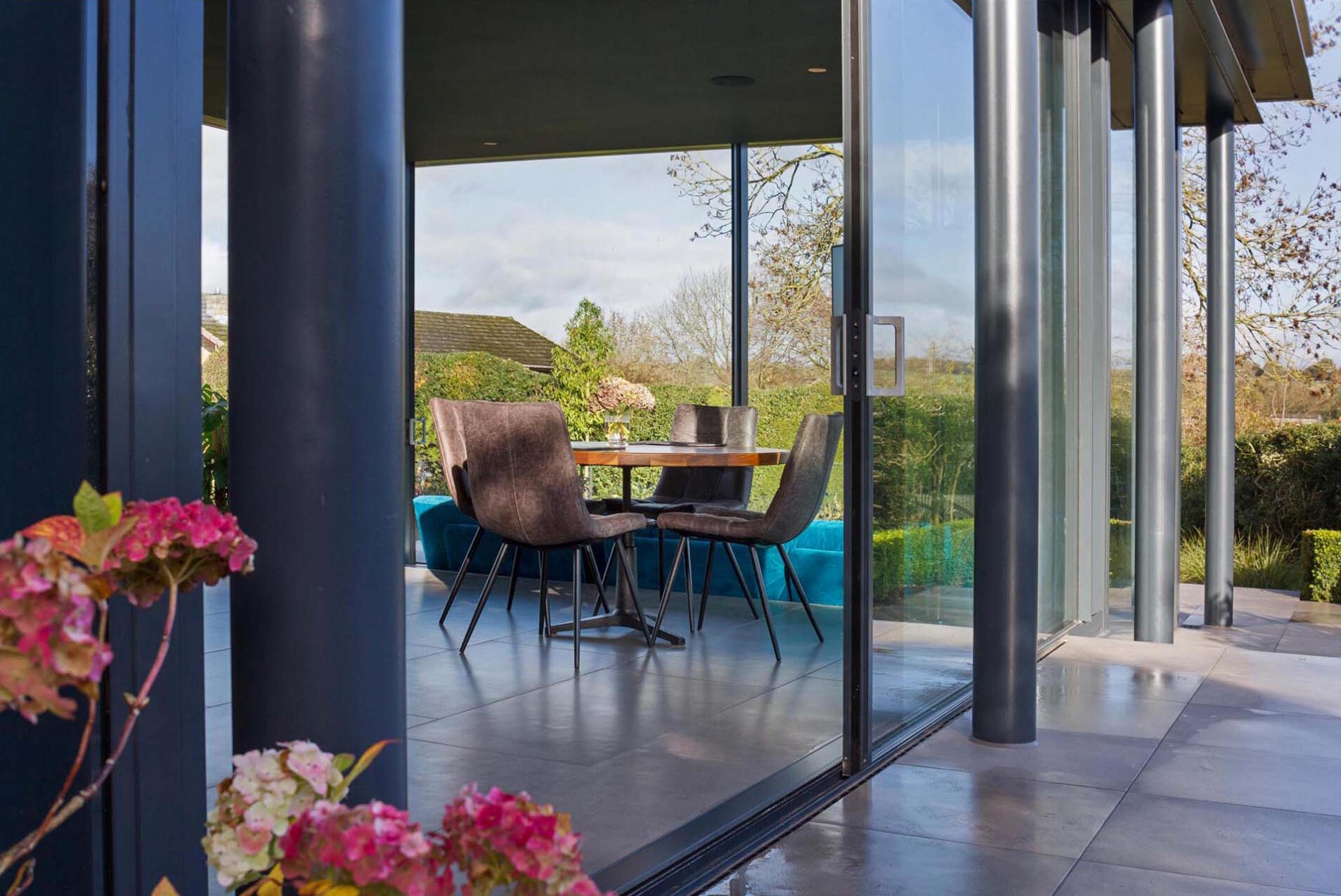 Floor-to-ceiling glass doors bring in natural light and fresh air, creating a bright and open living space.