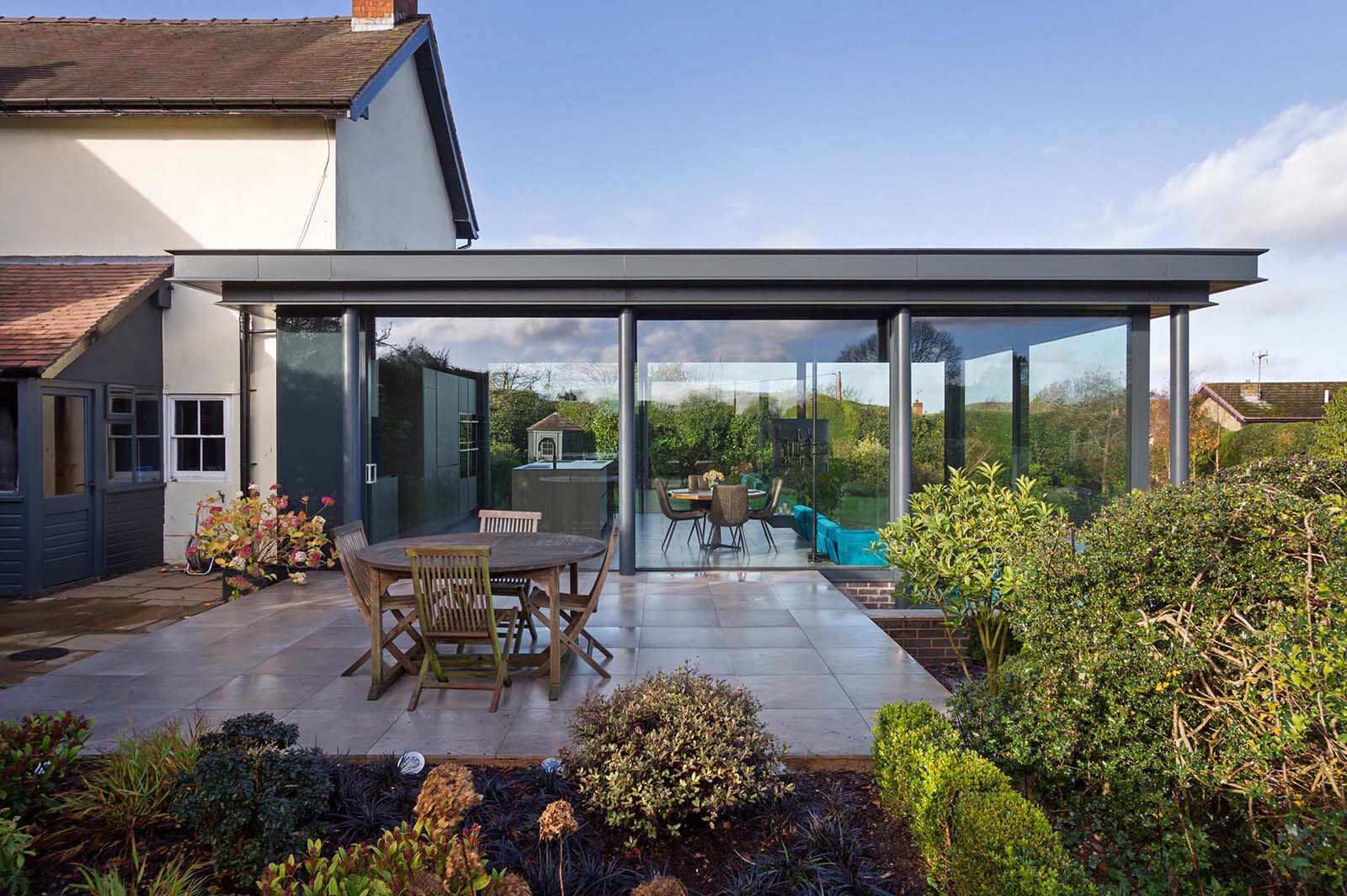 A spacious patio extends the living area outdoors, creating the perfect setup for dining and relaxing in the garden.