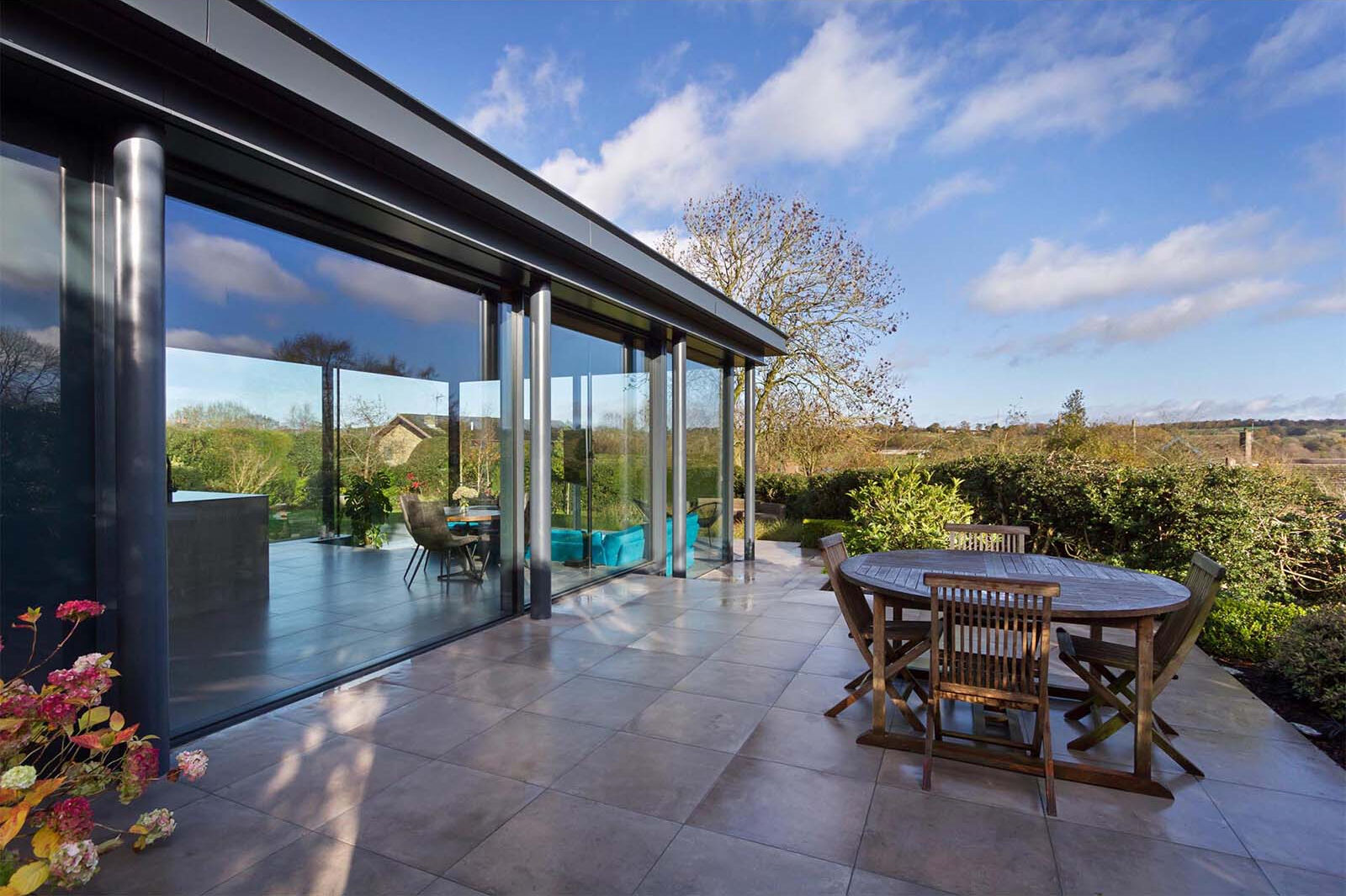 A spacious patio extends the living area outdoors, creating the perfect setup for dining and relaxing in the garden.