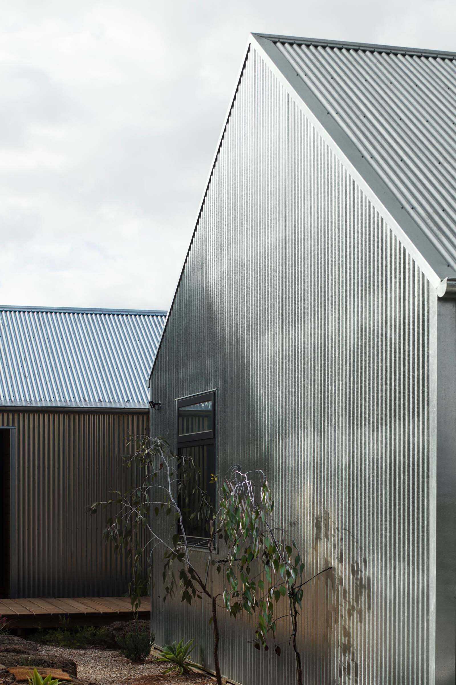 Corrugated galvanized steel cladding wraps this home, creating a low-maintenance exterior that gradually softens in appearance over time.