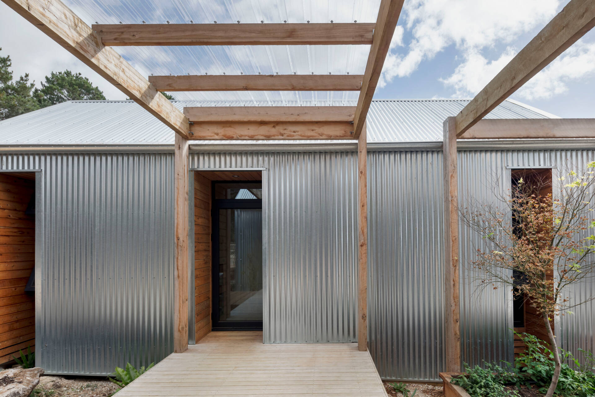 Corrugated galvanized steel cladding wraps this home, creating a low-maintenance exterior that gradually softens in appearance over time.