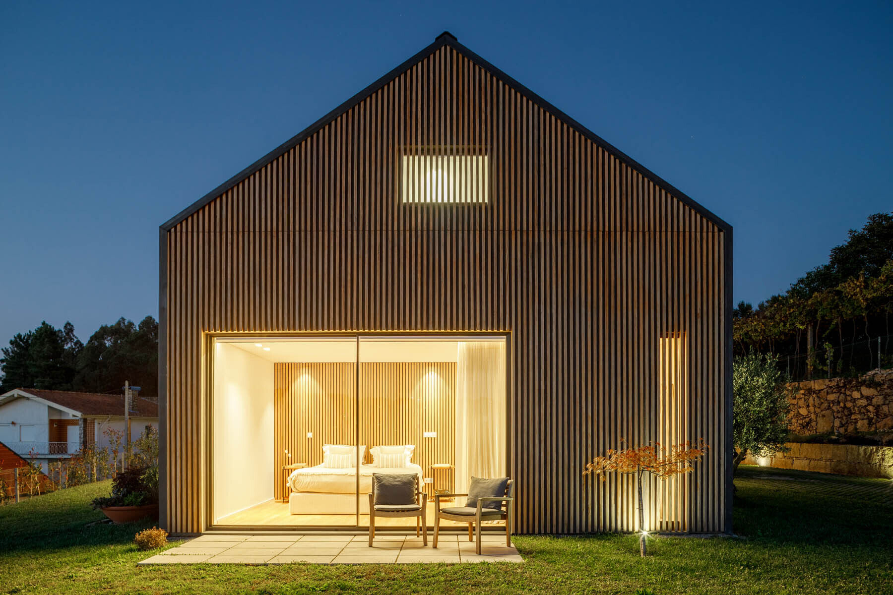 Wood slats wrap the exterior of this home, creating a clean facade that shifts between solid and open as you move around it.