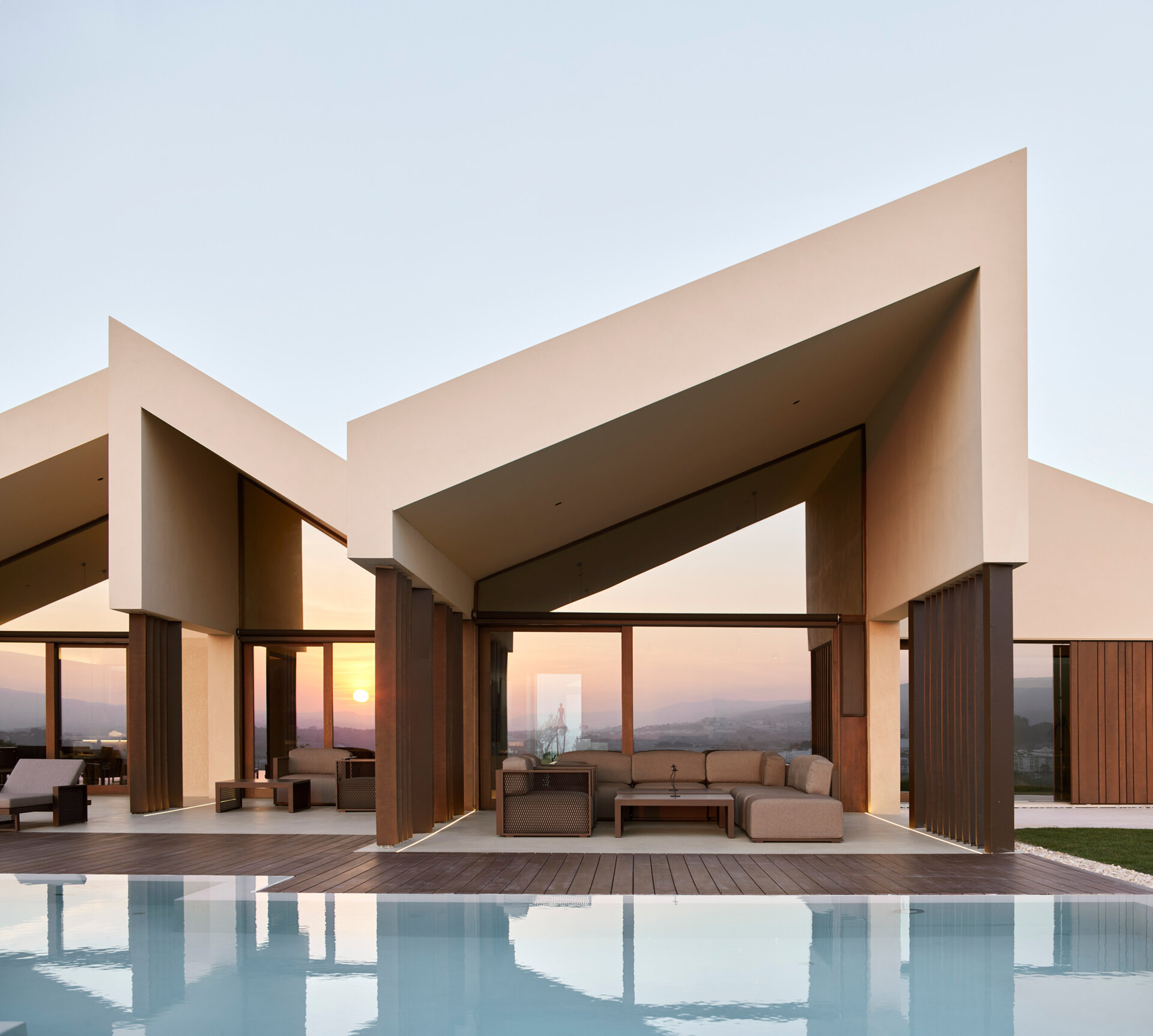 A contemporary home in Valencia reimagines traditional gable roofs with shifting volumes, textured stucco, and a soft, earthy palette that blends into the hillside.