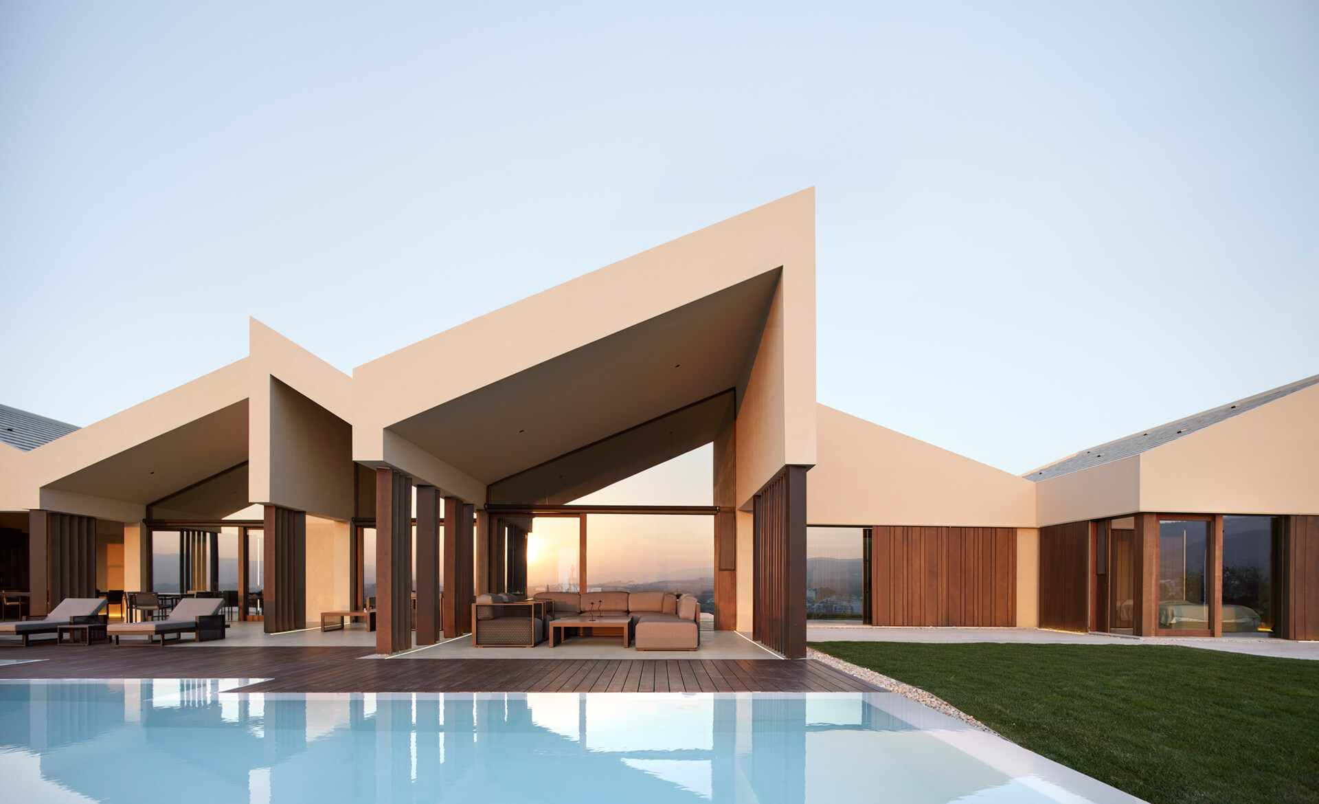 A contemporary home in Valencia reimagines traditional gable roofs with shifting volumes, textured stucco, and a soft, earthy palette that blends into the hillside.