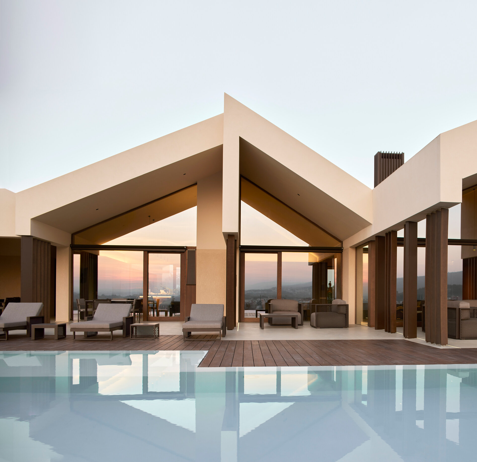 A contemporary home in Valencia reimagines traditional gable roofs with shifting volumes, textured stucco, and a soft, earthy palette that blends into the hillside.