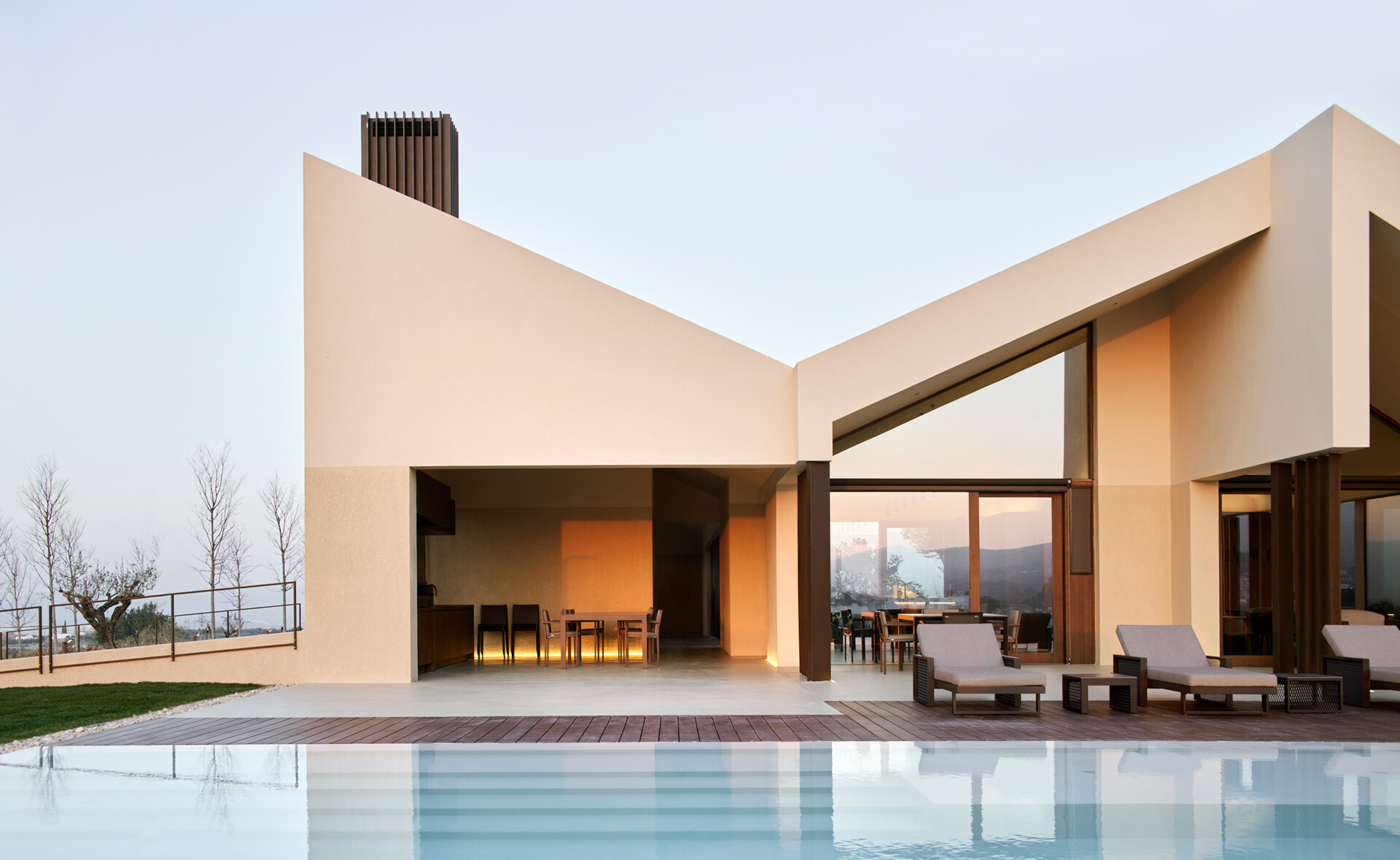A contemporary home in Valencia reimagines traditional gable roofs with shifting volumes, textured stucco, and a soft, earthy palette that blends into the hillside.