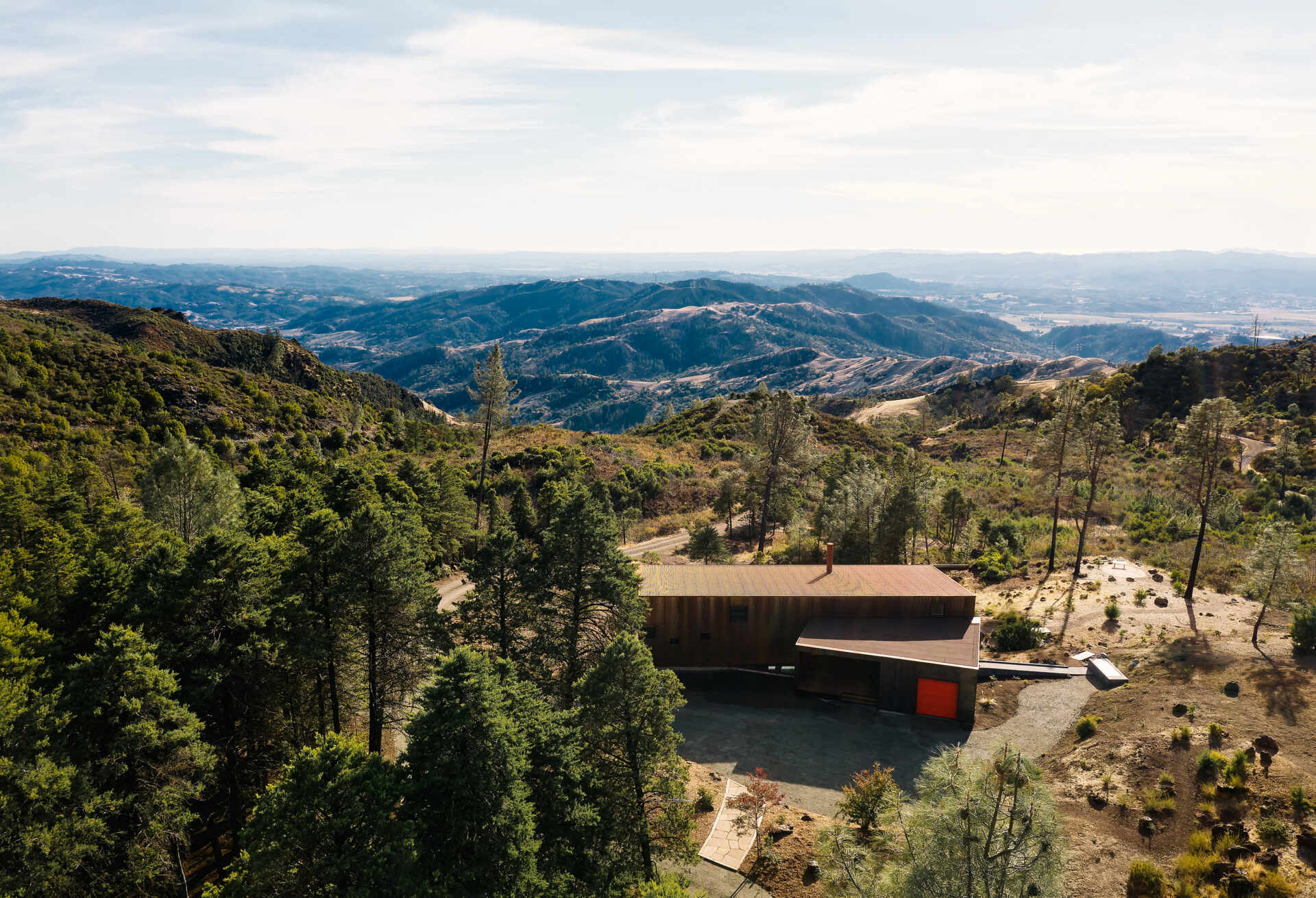 By reusing 90 percent of the original foundation, this home reduces waste while creating a simple, grounded form that follows the ridgeline.
