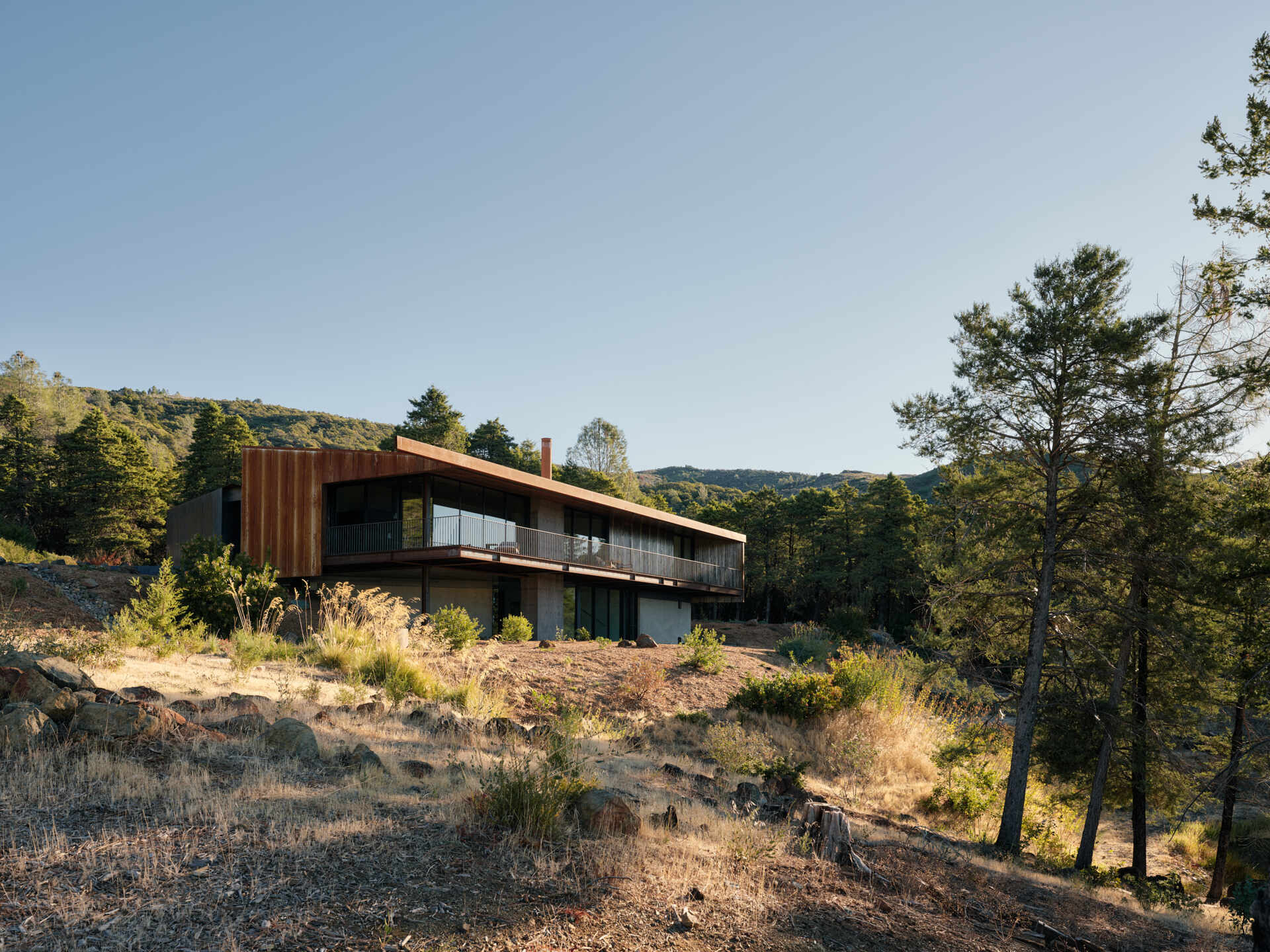 By reusing 90 percent of the original foundation, this home reduces waste while creating a simple, grounded form that follows the ridgeline.