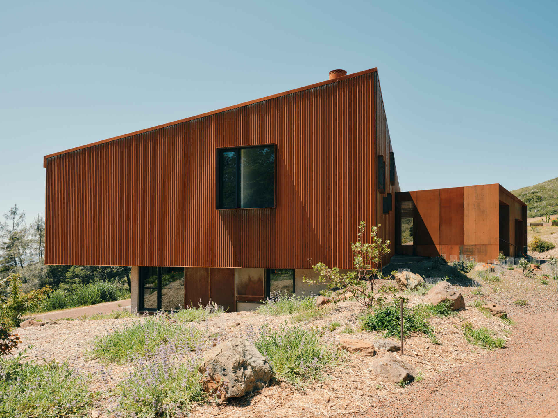 A corten steel exterior, ember screens, and integrated sprinklers work together to protect this home while keeping maintenance low.