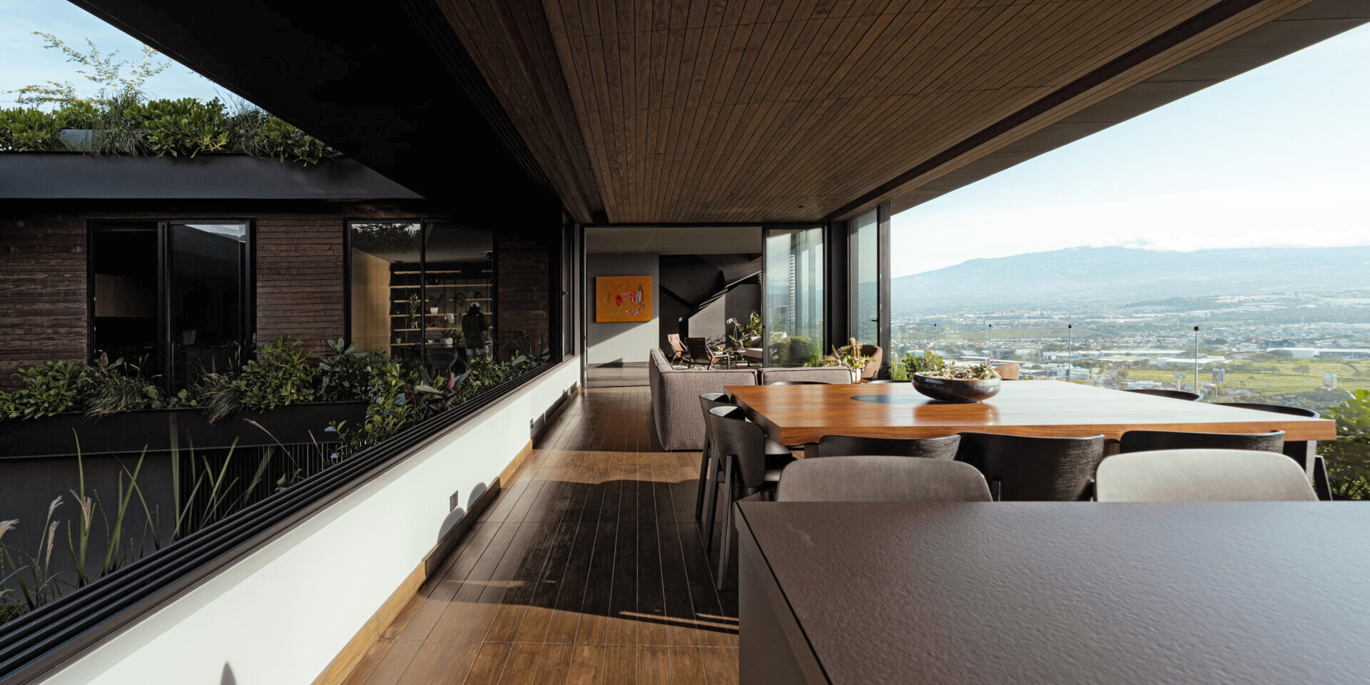 Open, light-filled interiors centered around a courtyard, with natural materials, filtered sunlight, and seamless flow between living spaces.