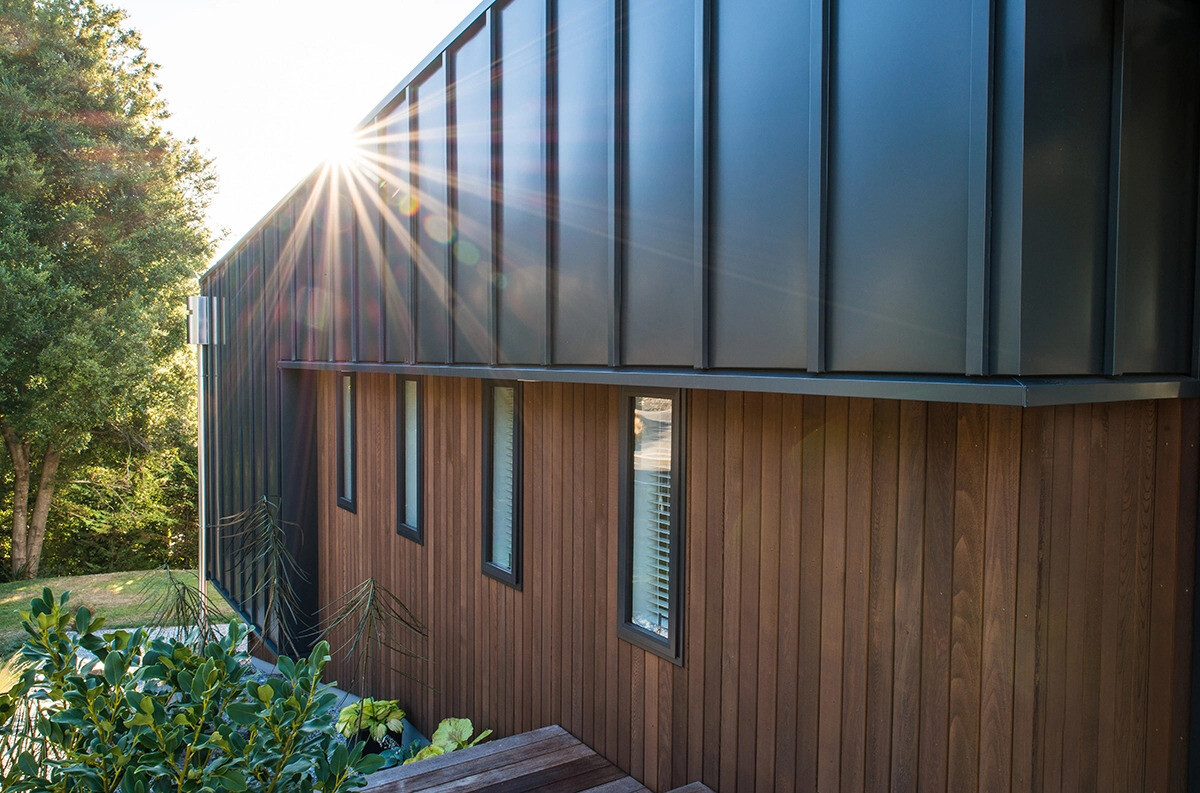 Dos volúmenes en forma de cuña revestidos de madera y metal negro mate se extienden por el empinado sitio de Queenstown mientras enmarcan las vistas del lago Wakatipu.