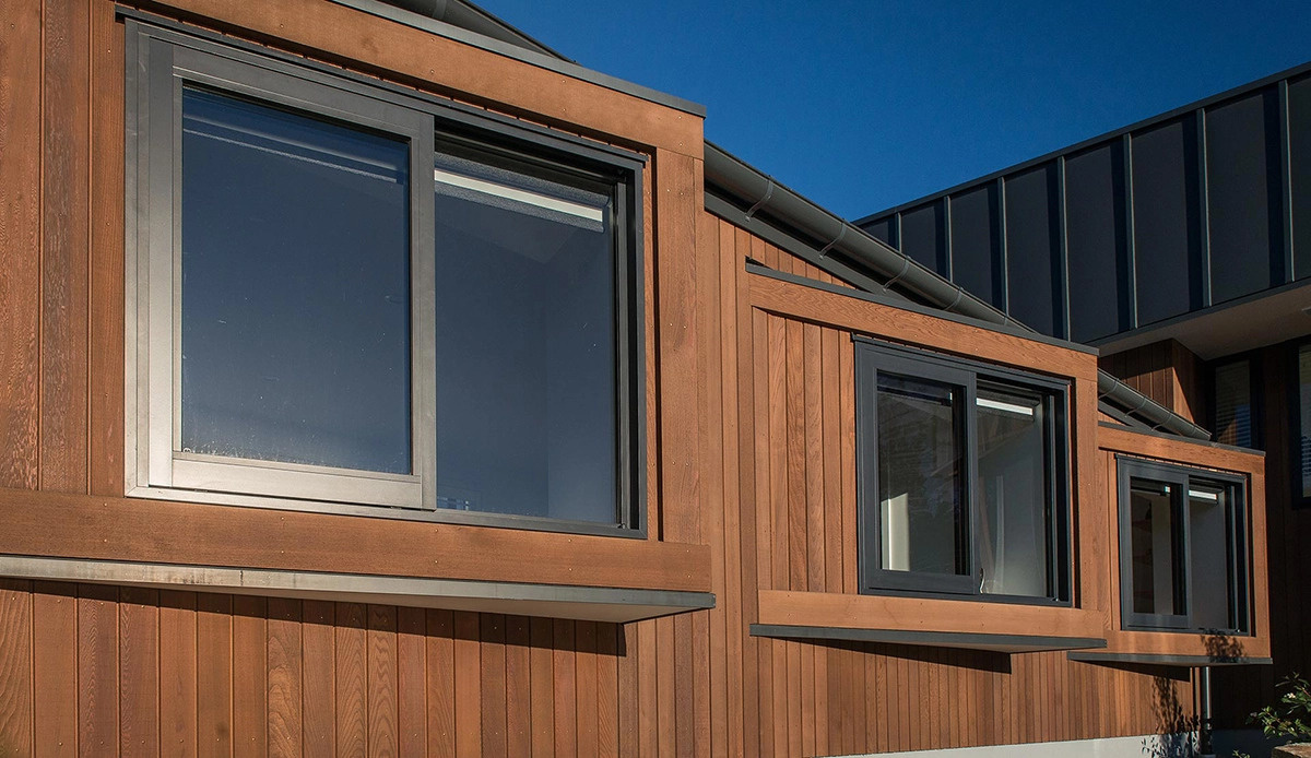 Dos volúmenes en forma de cuña revestidos de madera y metal negro mate se extienden por el empinado sitio de Queenstown mientras enmarcan las vistas del lago Wakatipu.