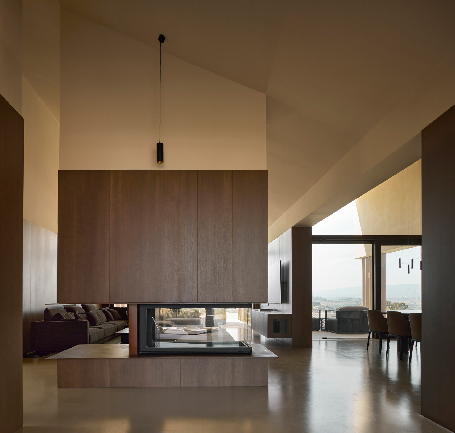 A warm living space with a fireplace and natural wood details opens directly to the outdoors, creating a seamless indoor-outdoor experience.