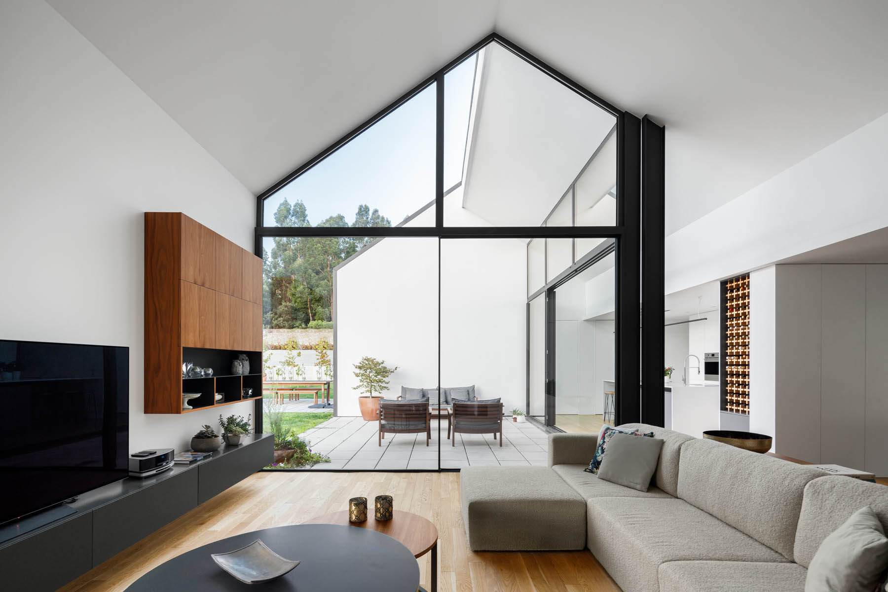 A gabled ceiling brings height and openness to the living room, with natural light filling the space from multiple directions.
