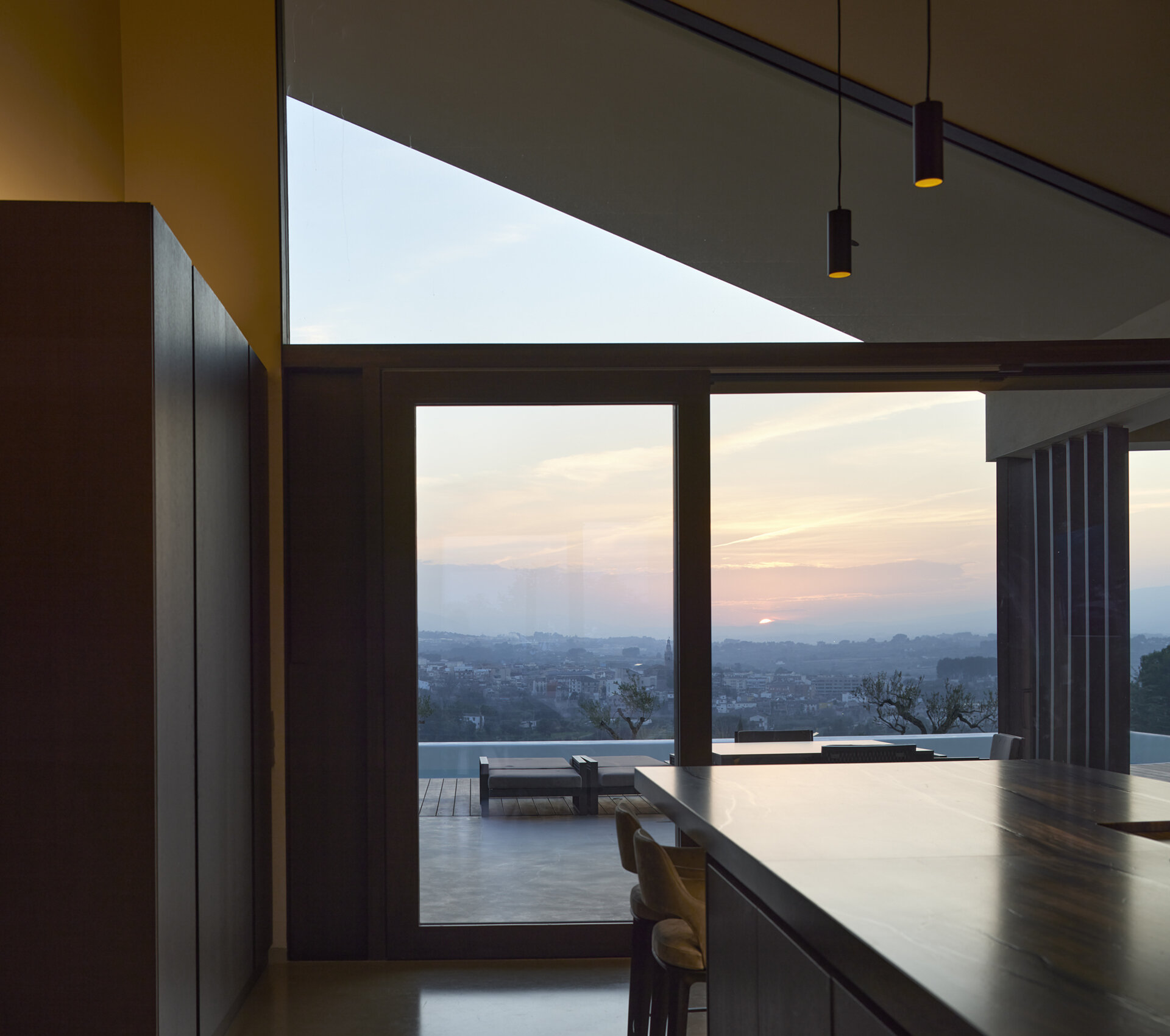 This modern kitchen connects directly to outdoor cooking and dining areas, designed for both everyday use and entertaining.