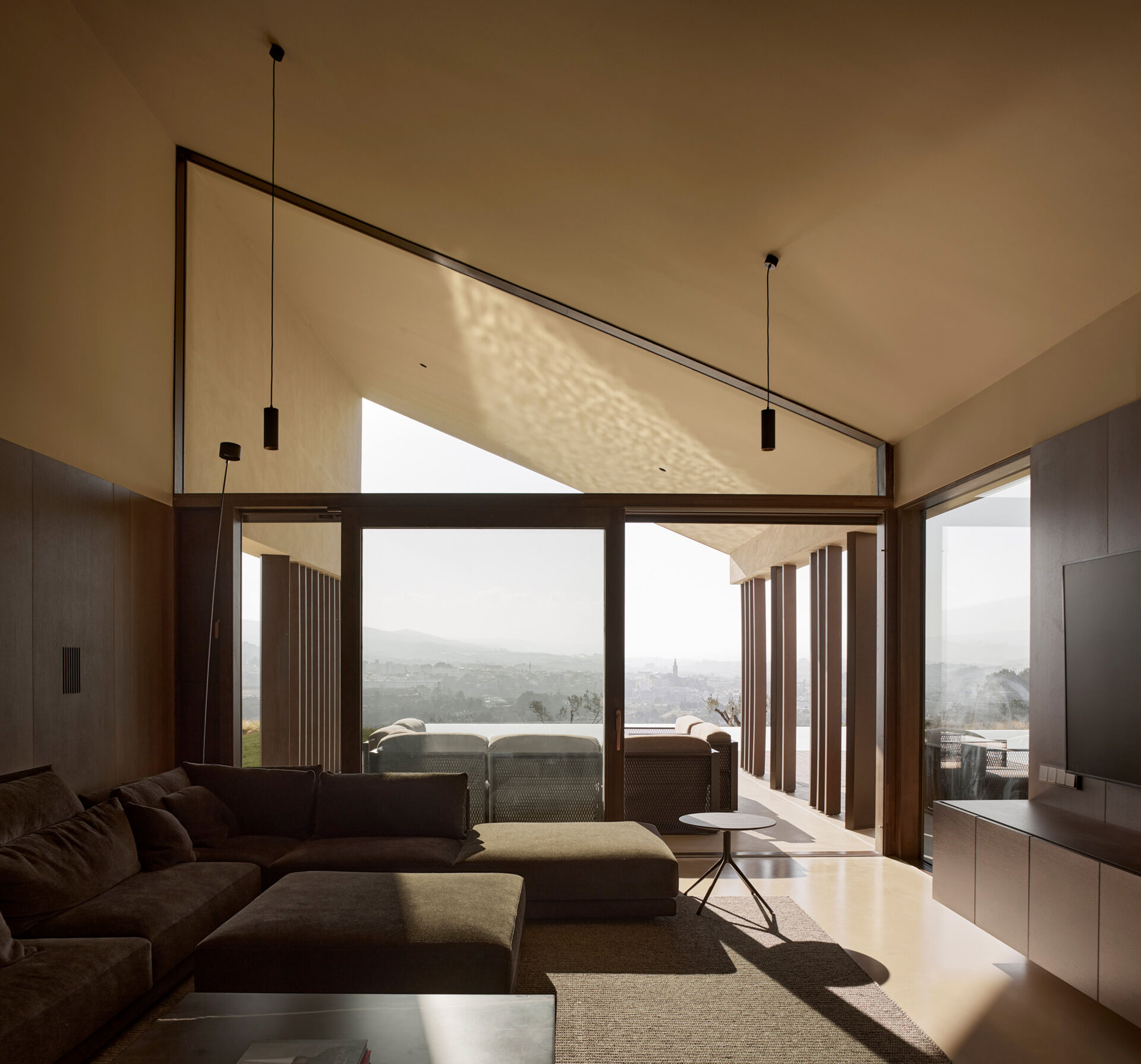 A warm living space with a fireplace and natural wood details opens directly to the outdoors, creating a seamless indoor-outdoor experience.