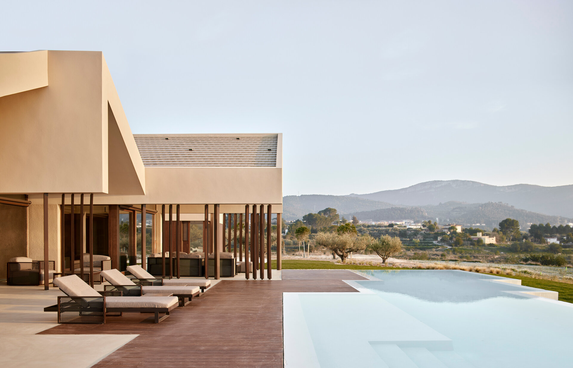 This pool area blends indoor and outdoor living with continuous flooring and warm wooden decking that shapes a calm, inviting space.