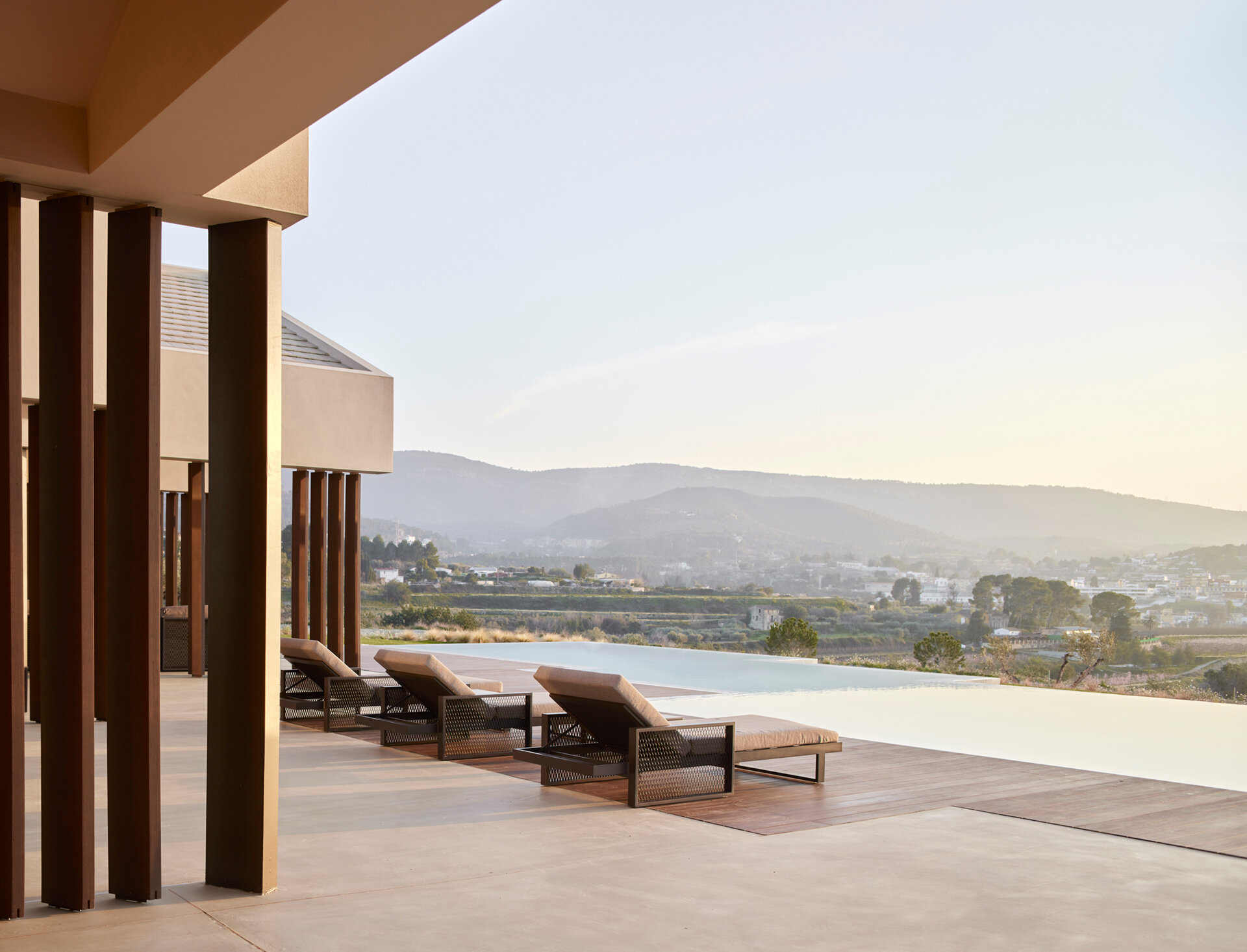 This pool area blends indoor and outdoor living with continuous flooring and warm wooden decking that shapes a calm, inviting space.