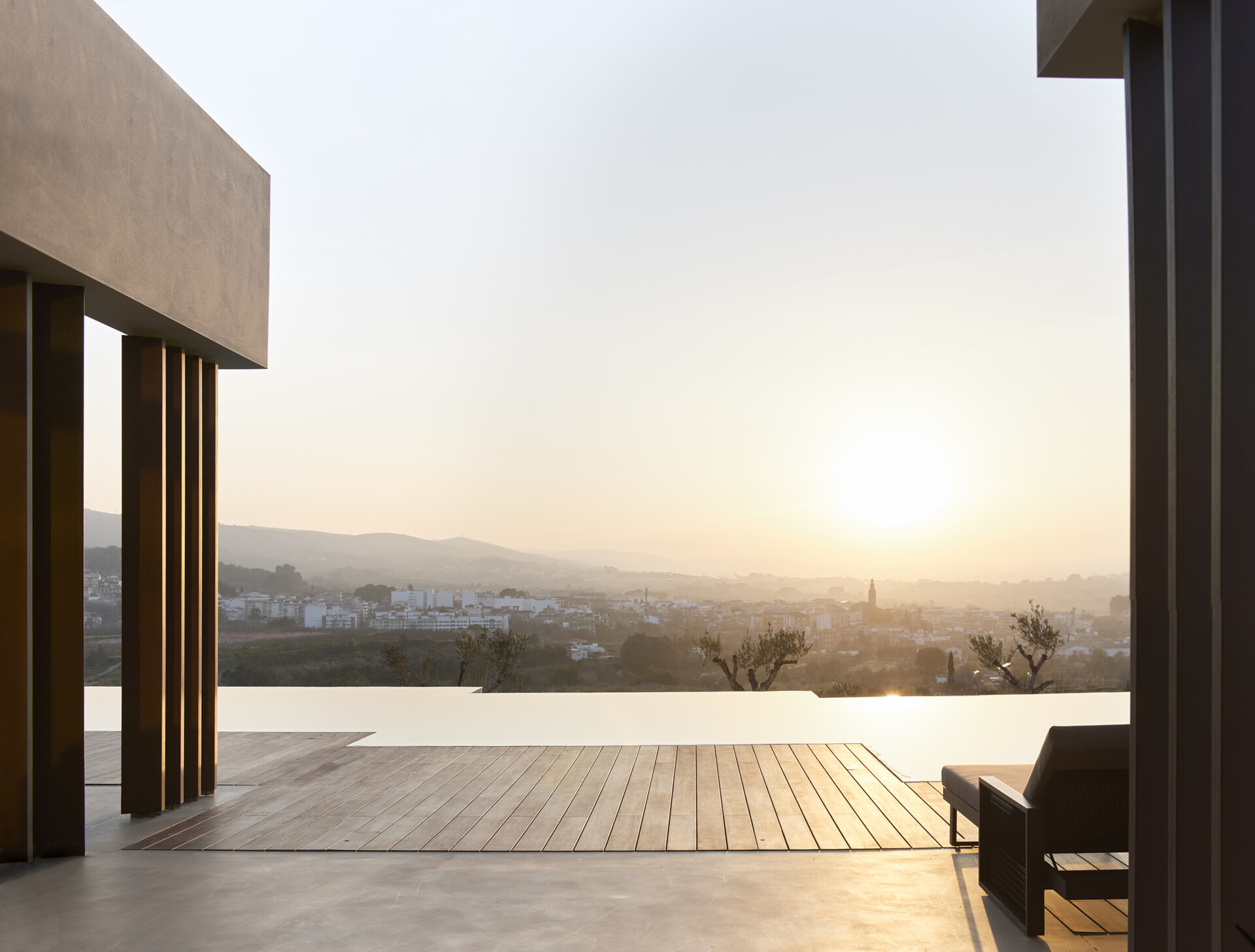 This pool area blends indoor and outdoor living with continuous flooring and warm wooden decking that shapes a calm, inviting space.