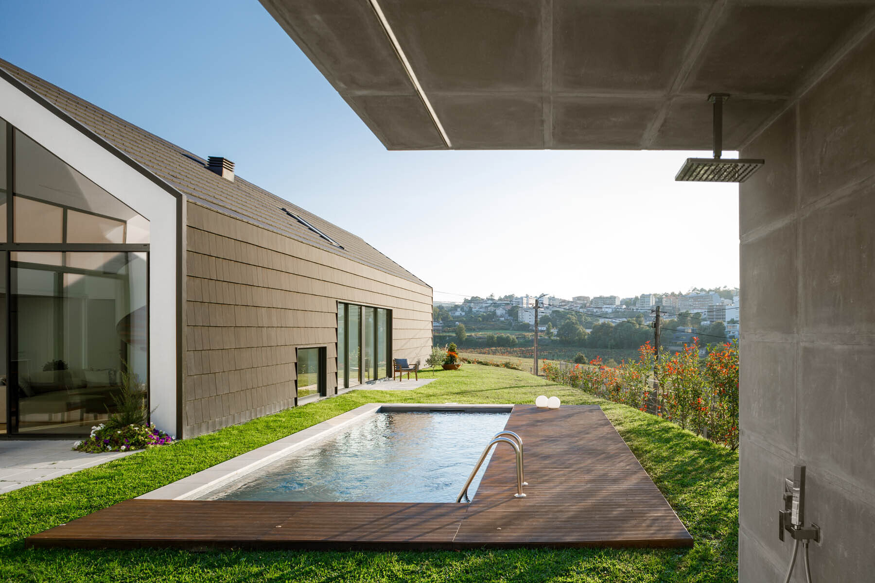 A central void opens the home to a patio, pool, and outdoor dining area, blending indoor living with open air spaces.