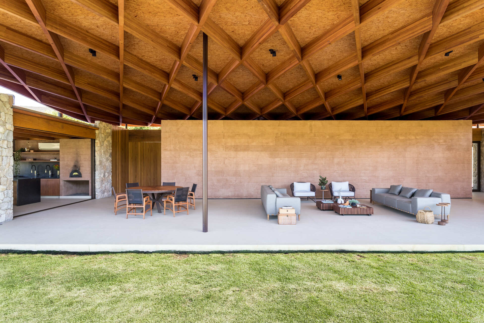 A sweeping wooden grid roof curves across the social spaces, supported by only eight slim metal pillars. It feels light and airy, framing views and glowing warmly at night.