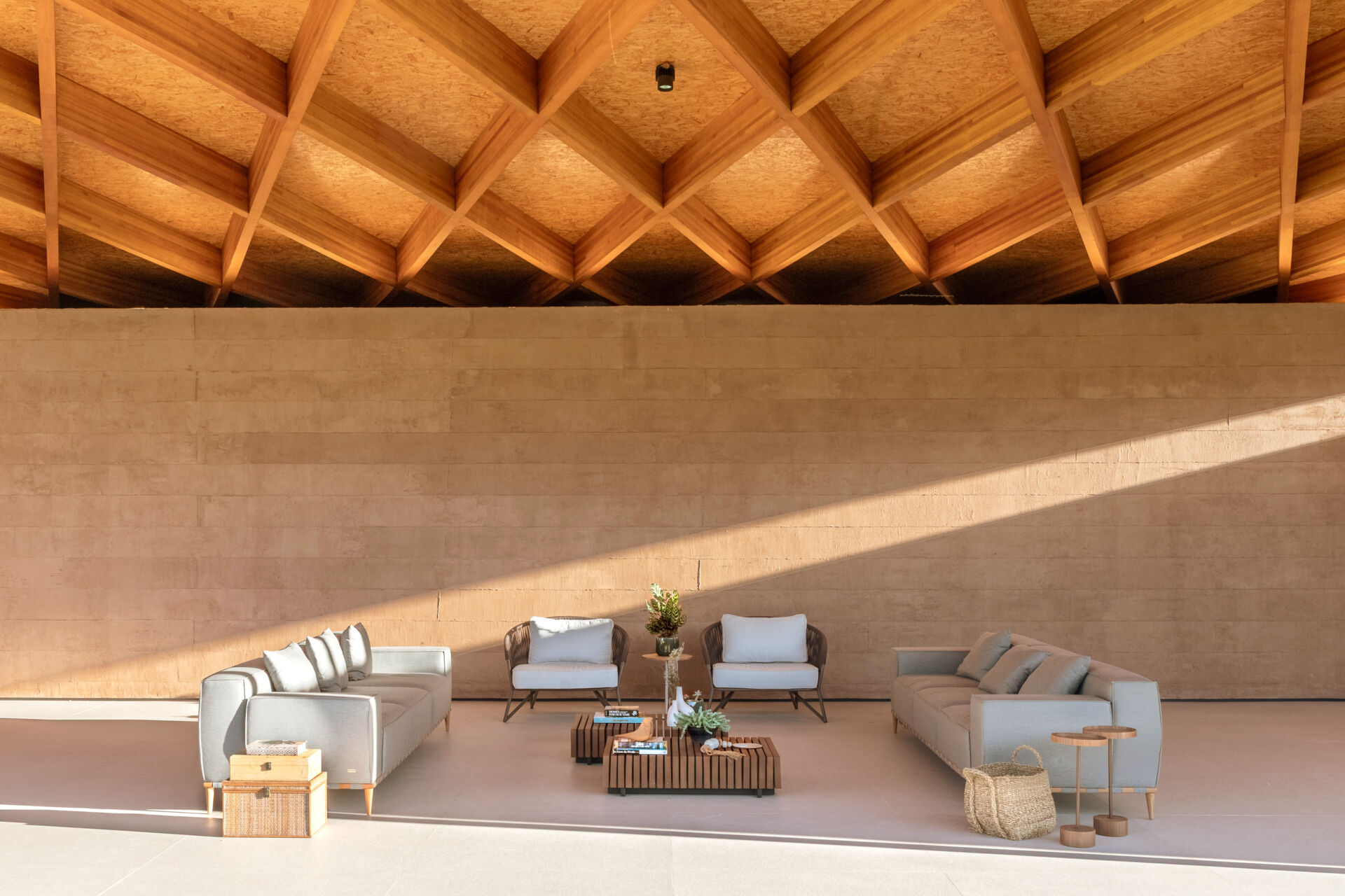 A sweeping wooden grid roof curves across the social spaces, supported by only eight slim metal pillars. It feels light and airy, framing views and glowing warmly at night.