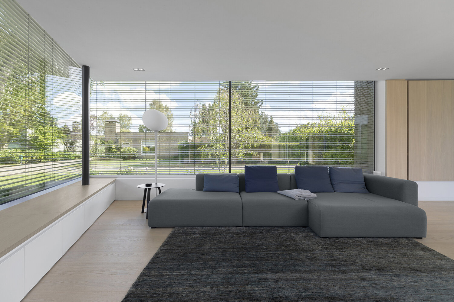 Una chimenea transparente conecta la sala de estar y la oficina en casa, aportando calidez y continuidad visual a ambos espacios.