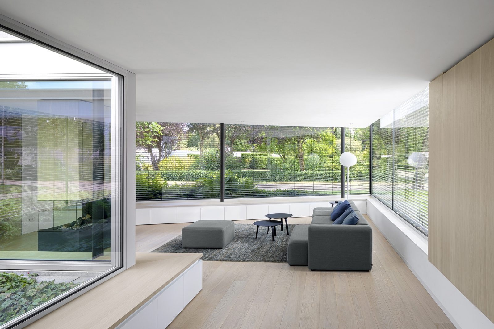 Una chimenea transparente conecta la sala de estar y la oficina en casa, aportando calidez y continuidad visual a ambos espacios.