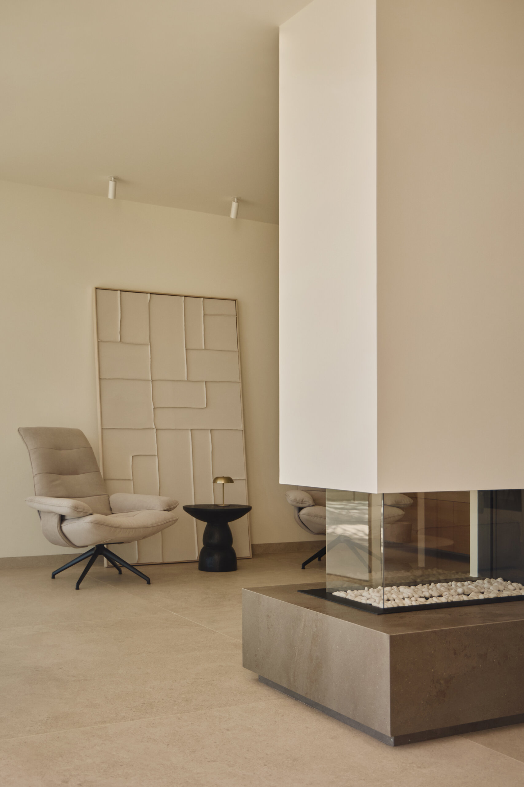 Inside the main living spaces, the connection to the sea becomes constant. The furniture is arranged to face the fireplace, while a sitting area is located on the other side of the fireplace.