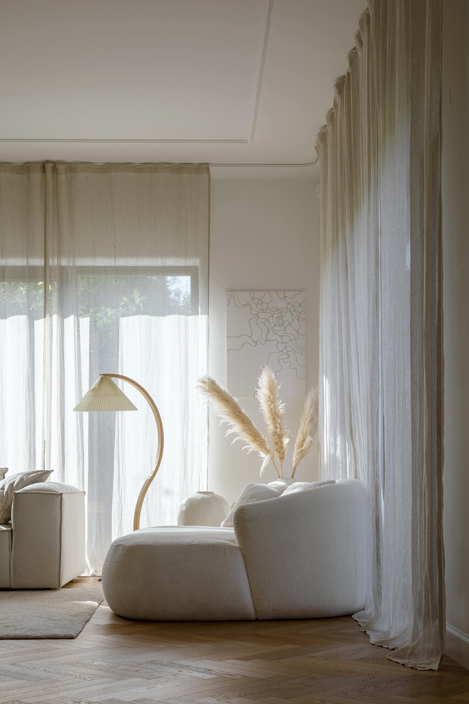 A modern living room with a long, multi-functional unit that integrates the firewood storage while doubling as seating. A built-in shelving niche and fireplace finish the living room space.