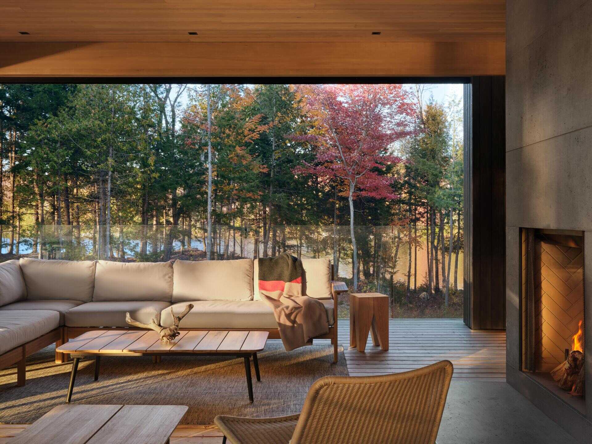 A spacious upper deck with treetop views, retractable screens, and an outdoor fireplace creates a seamless extension of the living space into the forest canopy.